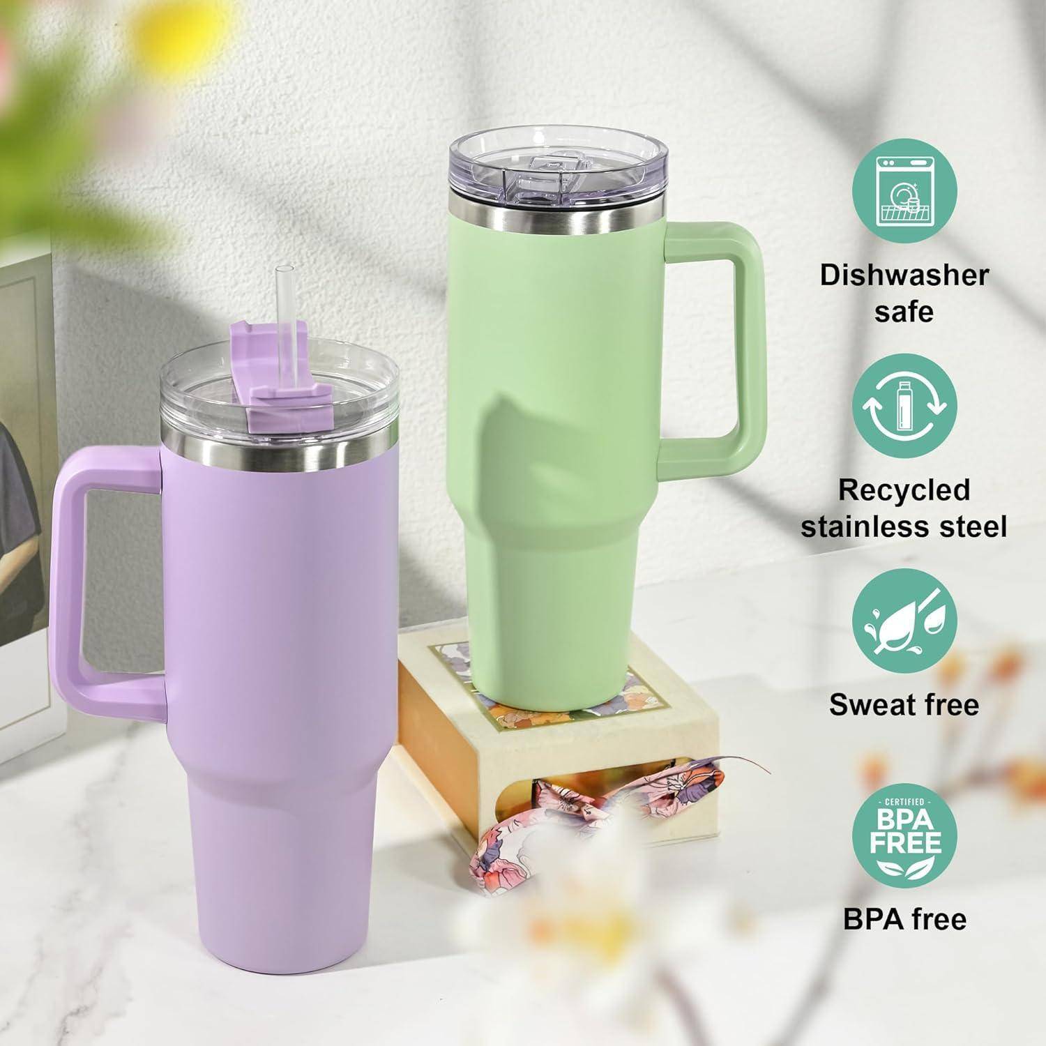 Zwei Becher mit Henkeln, einer in Lavendel und einer in Grün, auf einem Tisch. Symbole zeigen Eigenschaften an: spülmaschinenfest, recycelter Stahl, schweißfrei, BPA-frei.