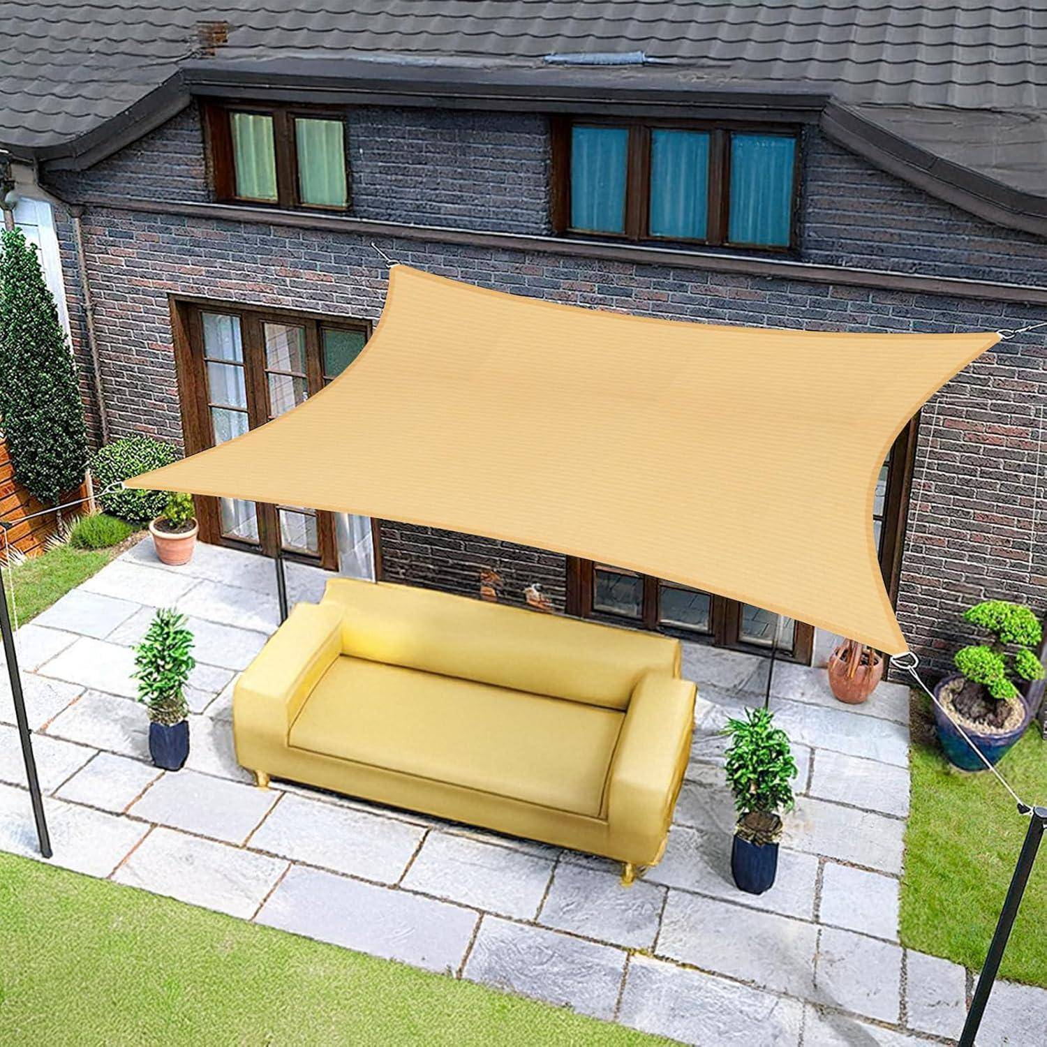 Terasse im Freien mit einem gelben Sofa unter einem großen beigen Sonnenschirm. Der Bereich ist von Kübelpflanzen gesäumt und ein Backsteinhaus befindet sich im Hintergrund.
