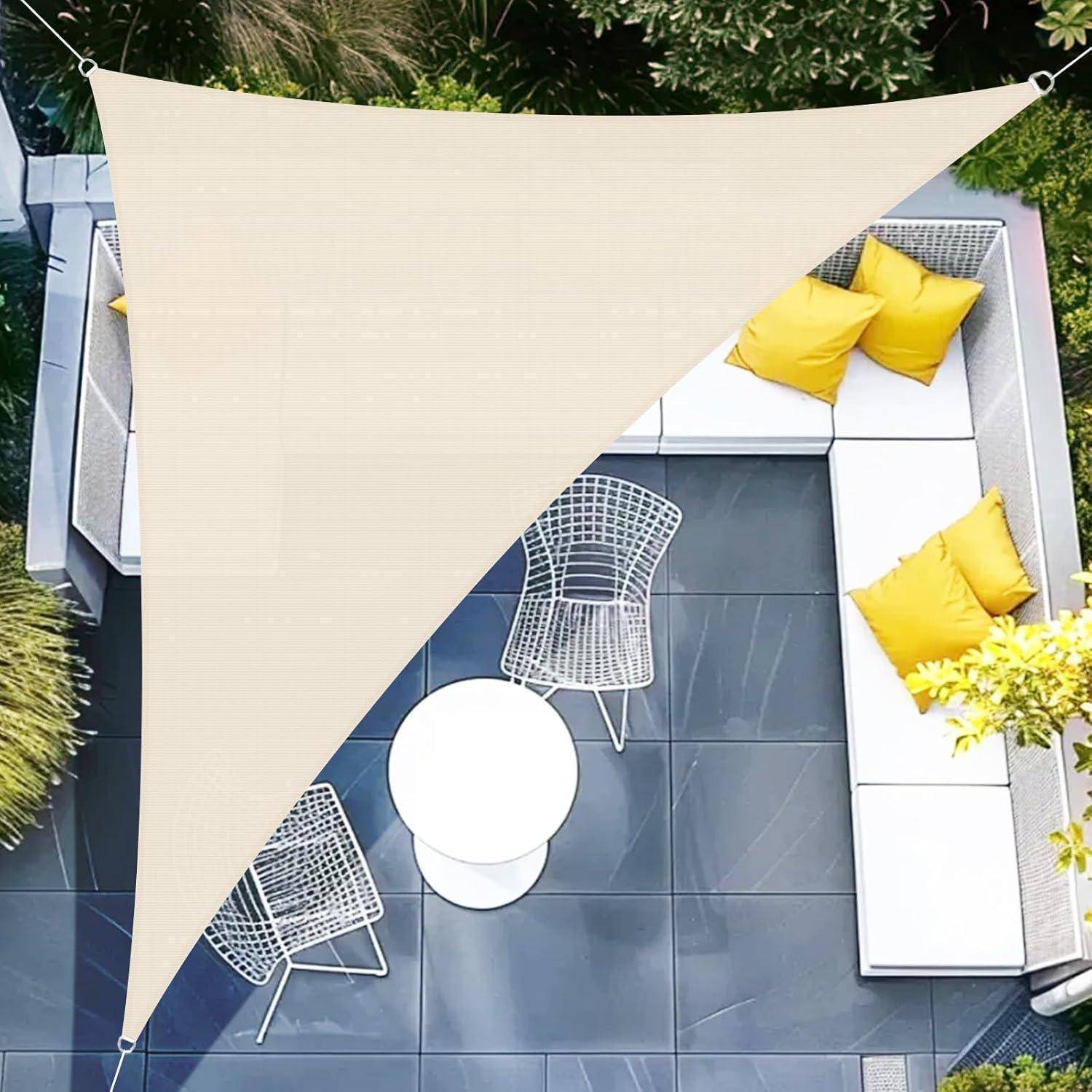 Luftaufnahme einer modernen Terrasse mit einem weißen Segel-Sonnensegel, weißen Sitzmöbeln und gelben Kissen, umgeben von Grünpflanzen.