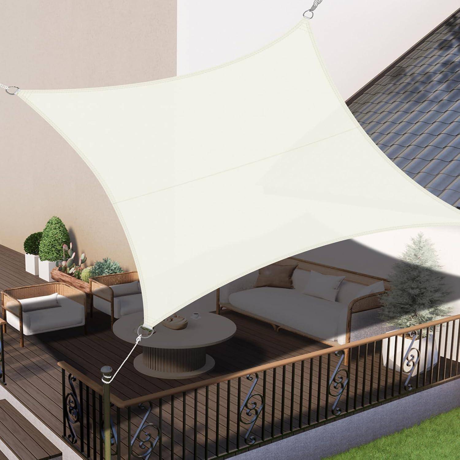 Eine Terrasse mit Outdoor-Möbeln, darunter ein Sofa, ein Stuhl, ein Couchtisch und Pflanzen, die von einem großen weißen Segel-Sonnensegel beschattet werden.