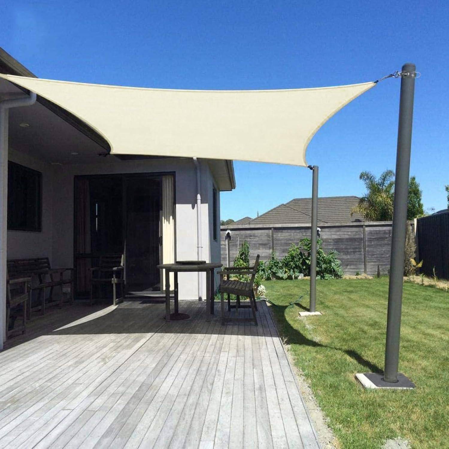 Eine Terrasse mit Holzboden wird von einem großen, dreieckigen cremefarbenen Segel beschattet. Im Hintergrund befinden sich Gartenmöbel und ein Holzzaun.