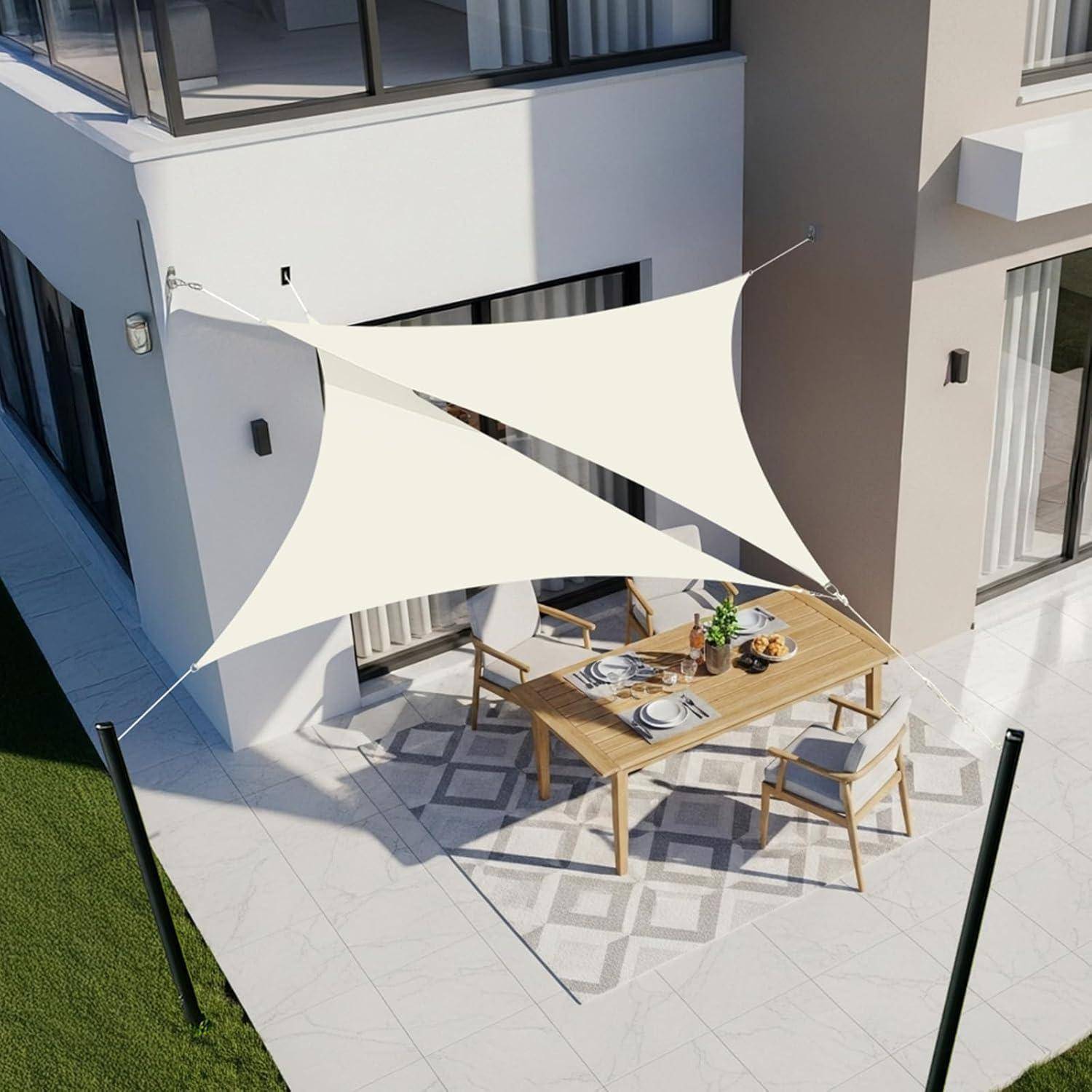 Draufsicht einer Terrasse im Freien mit einem dreieckigen Sonnensegel über einem Holzesstisch mit Stühlen auf einem gemusterten Teppich.