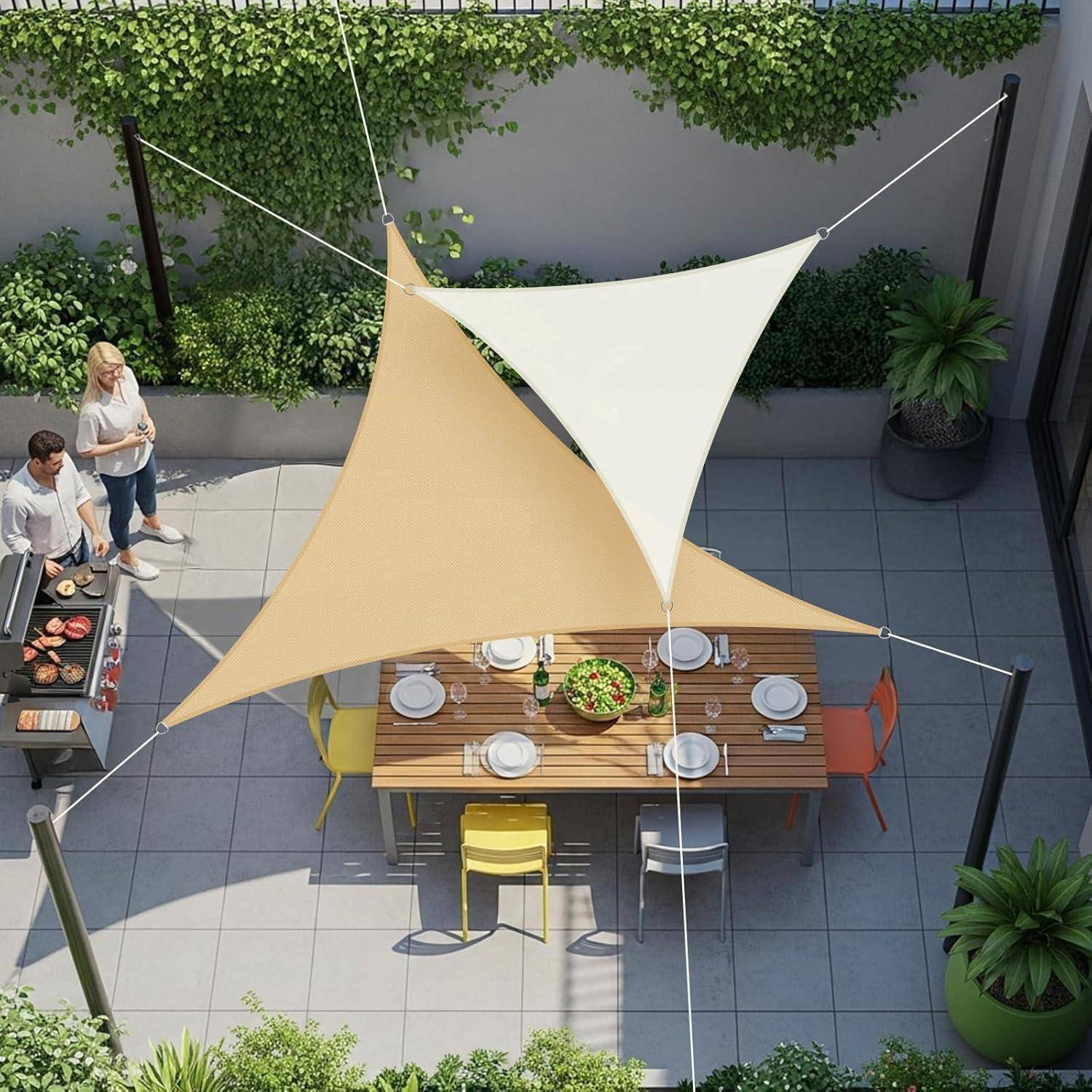 Draufsicht einer Terrasse mit einem für eine Mahlzeit gedeckten Esstisch, bunten Stühlen und einem Grillbereich. Zwei Personen stehen in der Nähe des Grills.