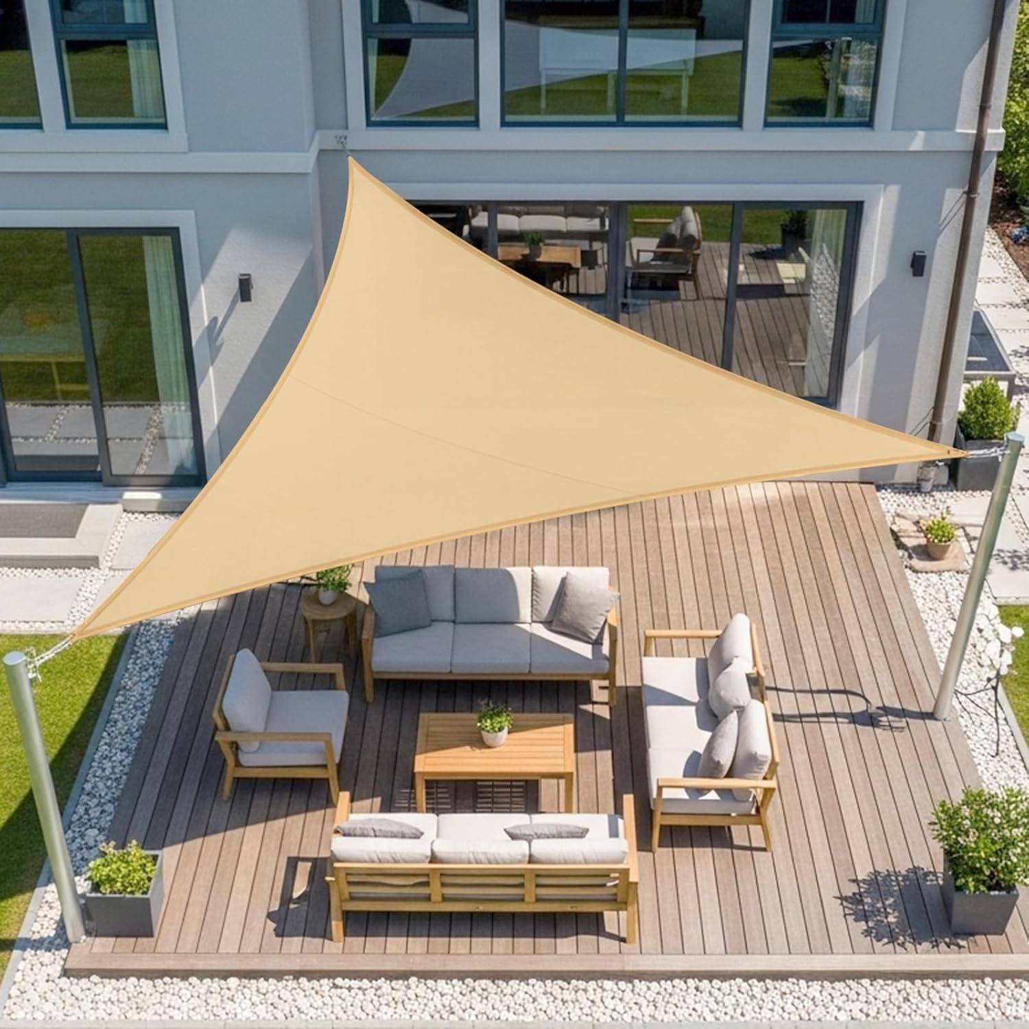 Luftaufnahme einer Terrasse mit einem beigen, dreieckigen Sonnensegel, Holzmöbeln mit grauen Kissen und Topfpflanzen auf einem Holzdeck.