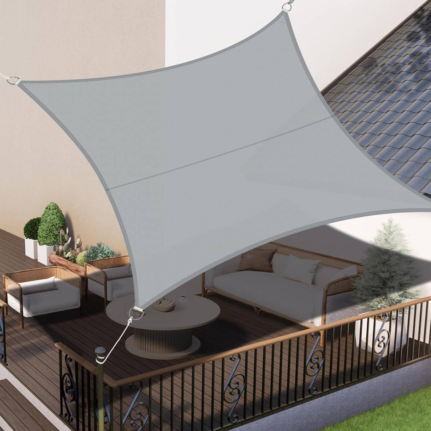 Eine Sonnensegel über einer modernen Terrasse im Freien mit Sitzgelegenheiten, Pflanzen und einem Geländer, das dem Bereich Schatten und Stil verleiht.