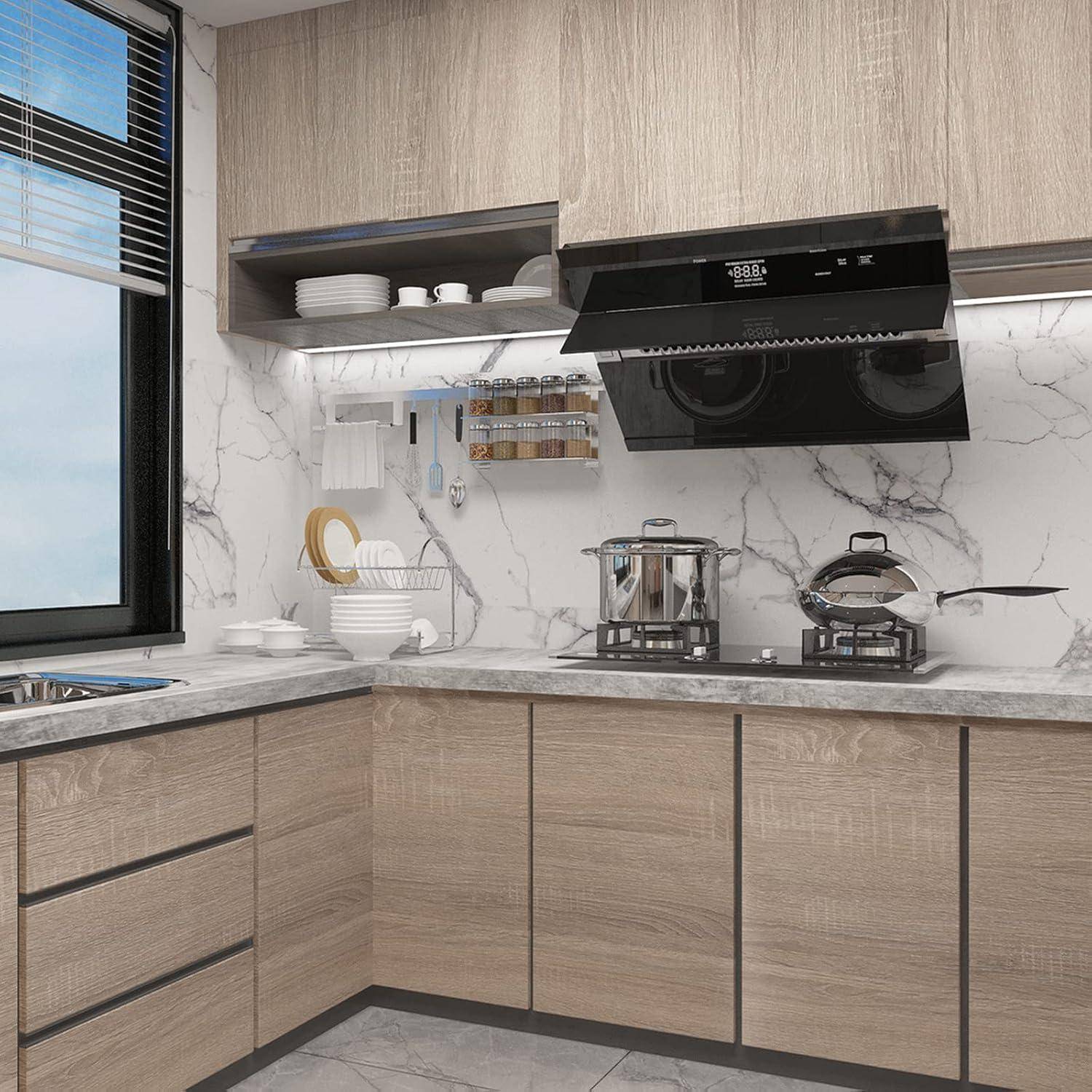 Moderne Küche mit hellen Holzschränken, Marmorbacksplash und einem Fenster auf der linken Seite. Arbeitsplatte mit Töpfen, einem Abtropfgestell und Küchenutensilien.