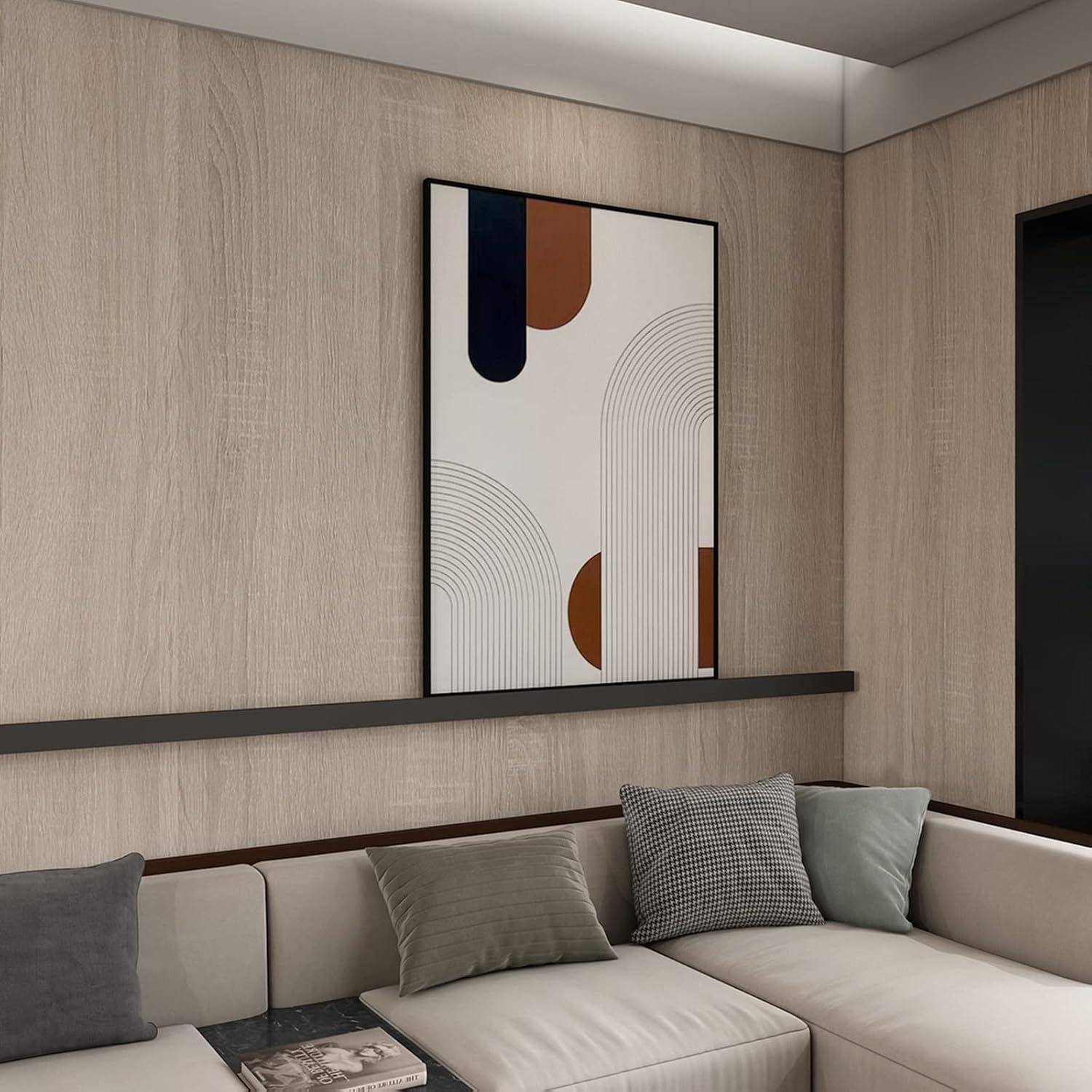 Ein moderner Wohnraum zeigt ein minimalistisches abstraktes Gemälde mit geschwungenen Linien und geometrischen Formen in Schwarz-, Weiß- und Brauntönen über einem Sofa.
