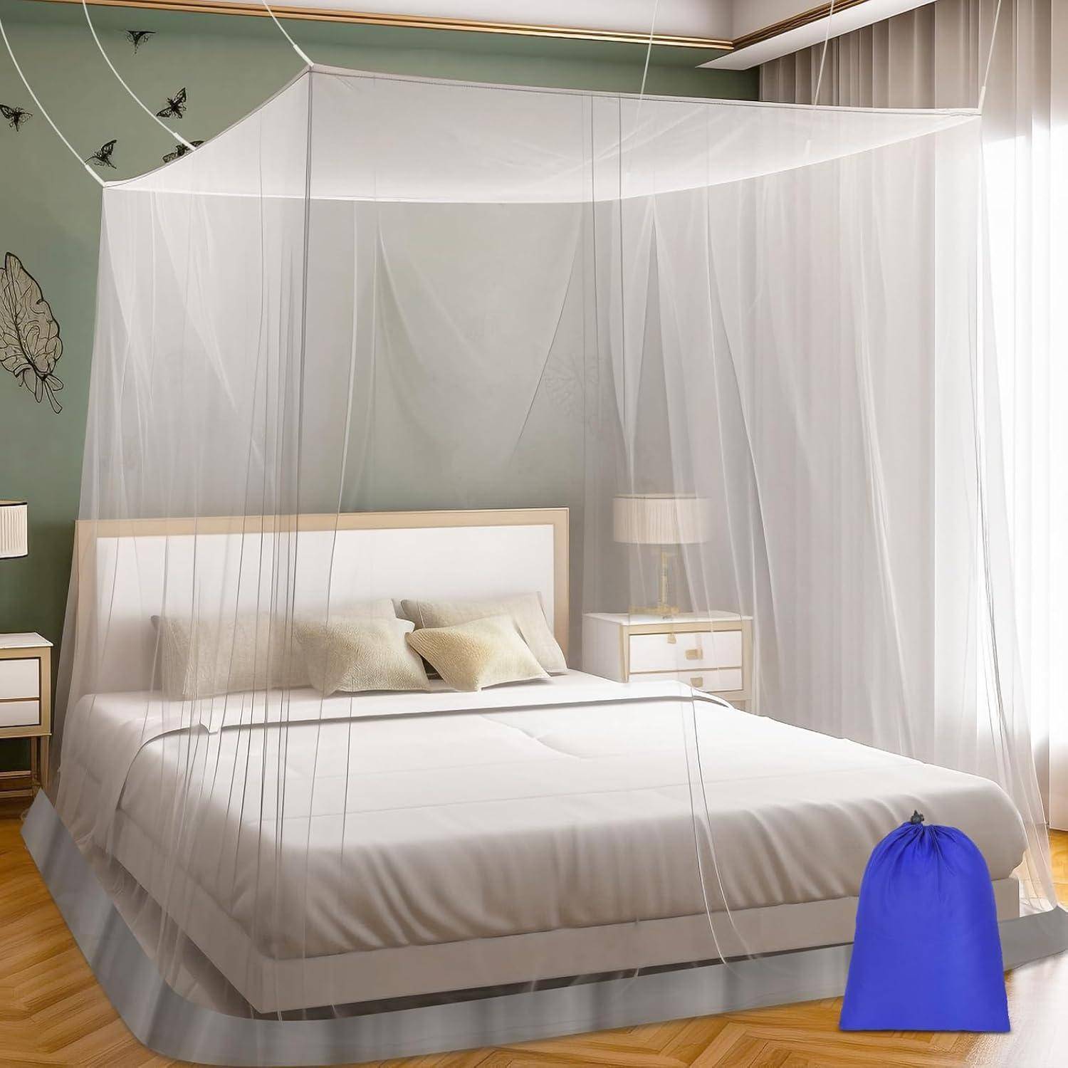 Ein Schlafzimmer mit einem Himmelbett, das mit einem transparenten Moskitonetz bedeckt ist, zwei Kissen, einem Nachttisch mit einer Lampe und einem blauen Aufbewahrungsbeutel am Fußende.