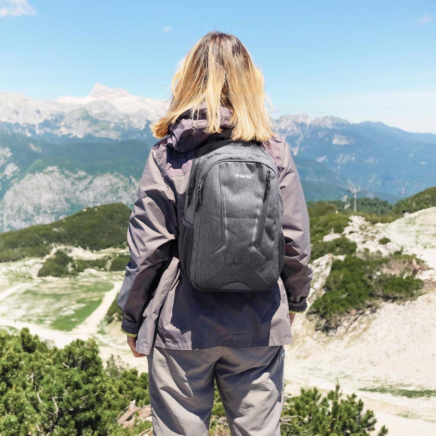 Eine Person mit einem grauen Rucksack und einer Jacke steht an einem Aussichtspunkt des Berges, von hinten zu sehen, mit einem malerischen Blick auf entfernte Berge und den Himmel.