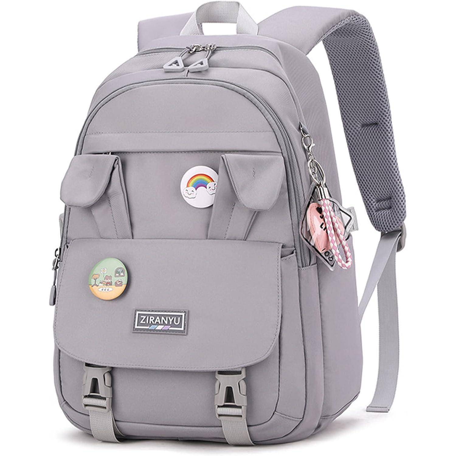 Ein grauer Rucksack mit zwei Vordertaschen ist mit bunten Anstecknadeln geschmückt, darunter eine Regenbogen- und eine Landschaftsnadel.