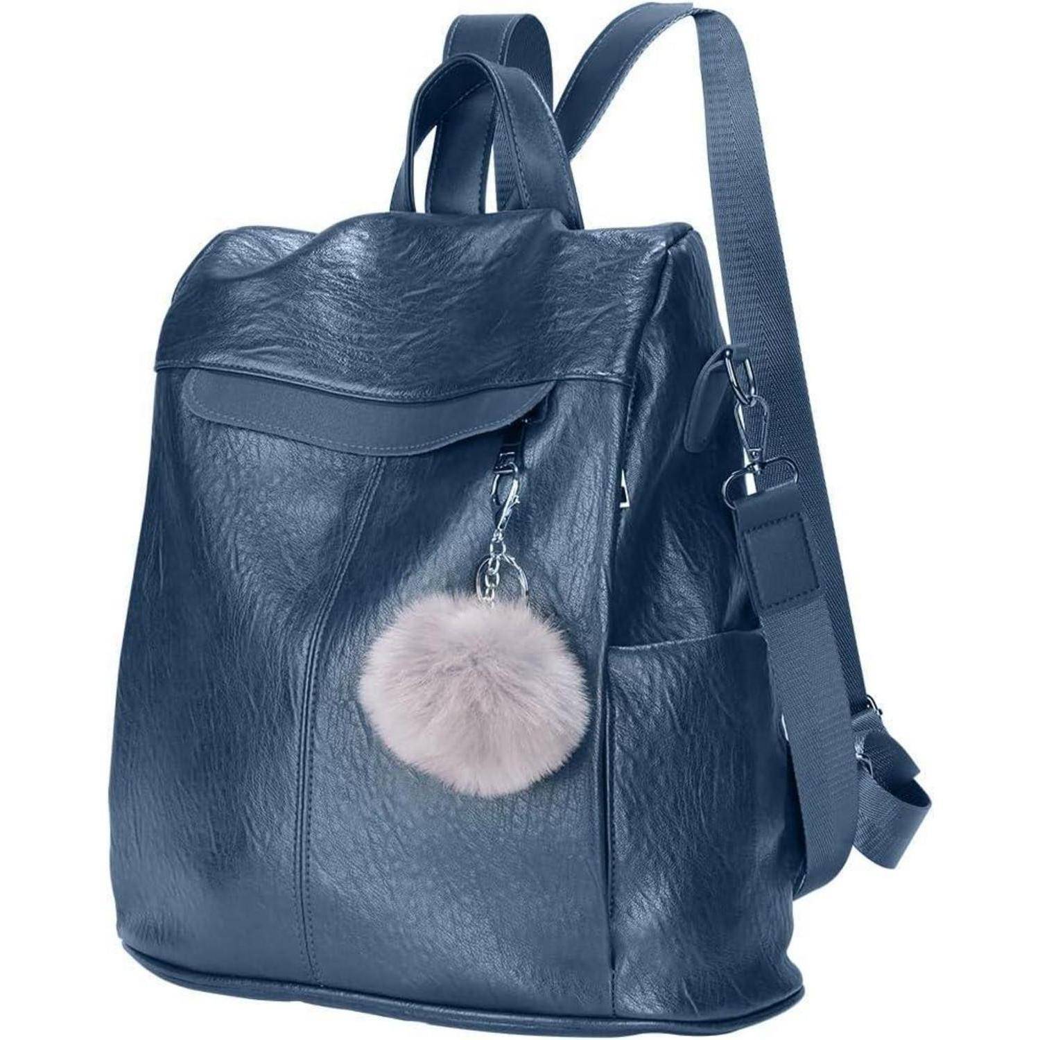 Ein stilvoller dunkelblauer Lederrucksack mit einem flauschigen, hellrosa Bommel-Schlüsselanhänger, der seitlich daran hängt, und verstellbaren Trägern.