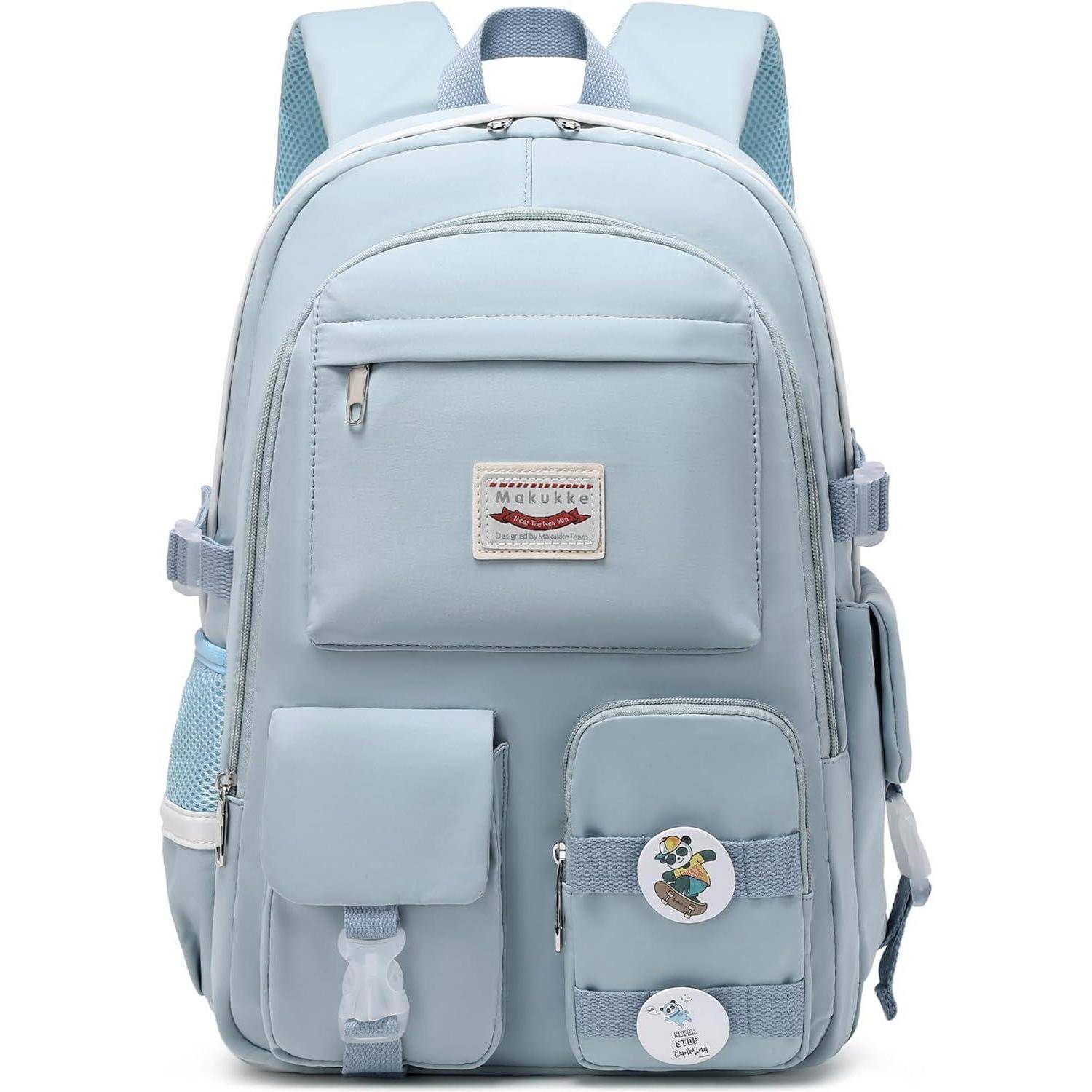 Ein hellblauer Rucksack mit mehreren Taschen und zwei runden Anstecknadeln mit kleinen Motiven.