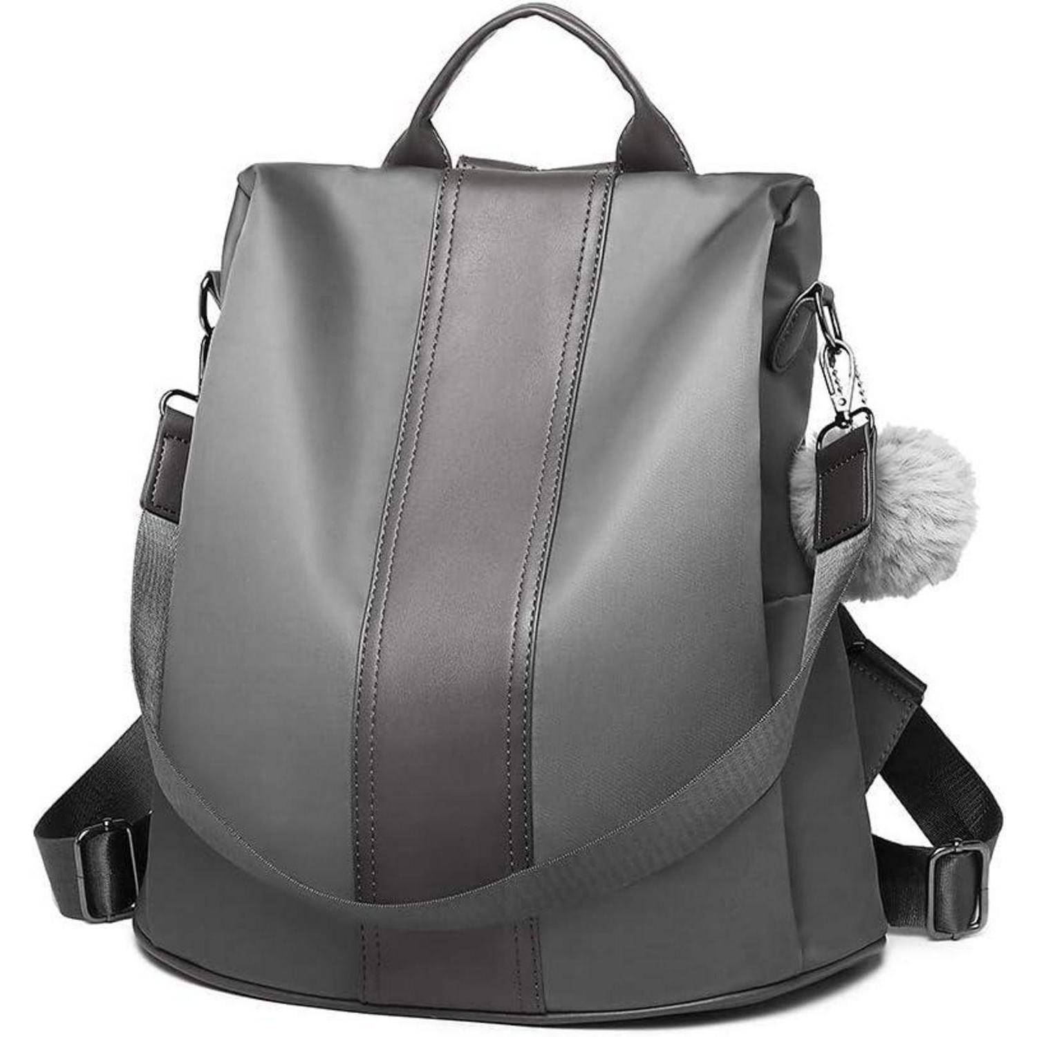 Ein schlanker, grauer Rucksack mit zwei Schultergurten und einem vertikalen Mittelstreifen, der an einer Seite einen flauschigen Pompon-Schlüsselanhänger trägt.