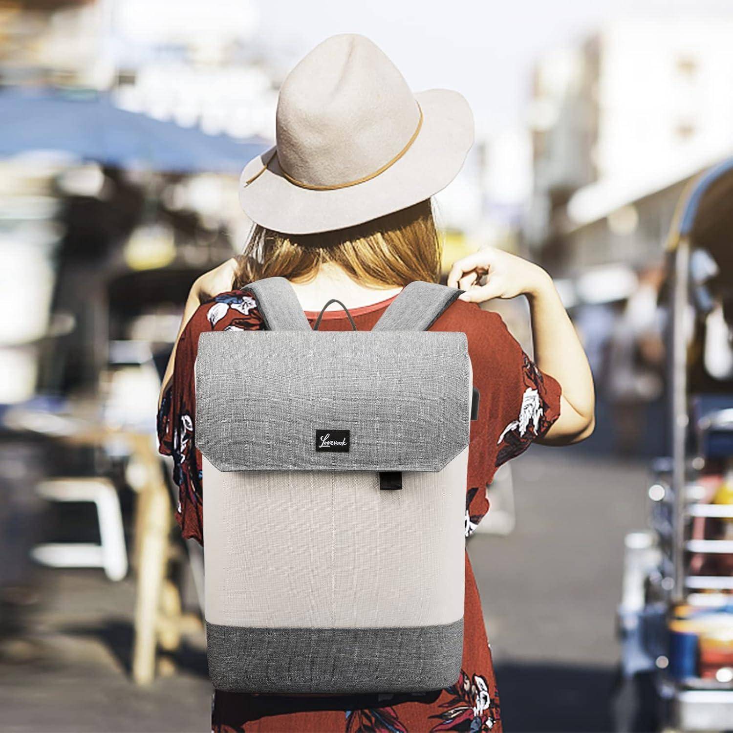 Eine Person mit Hut und rotem Shirt trägt einen grauen Rucksack und steht an einer sonnigen, verschwommenen Straße, was einen Reise- oder lässigen Ausflug andeutet.