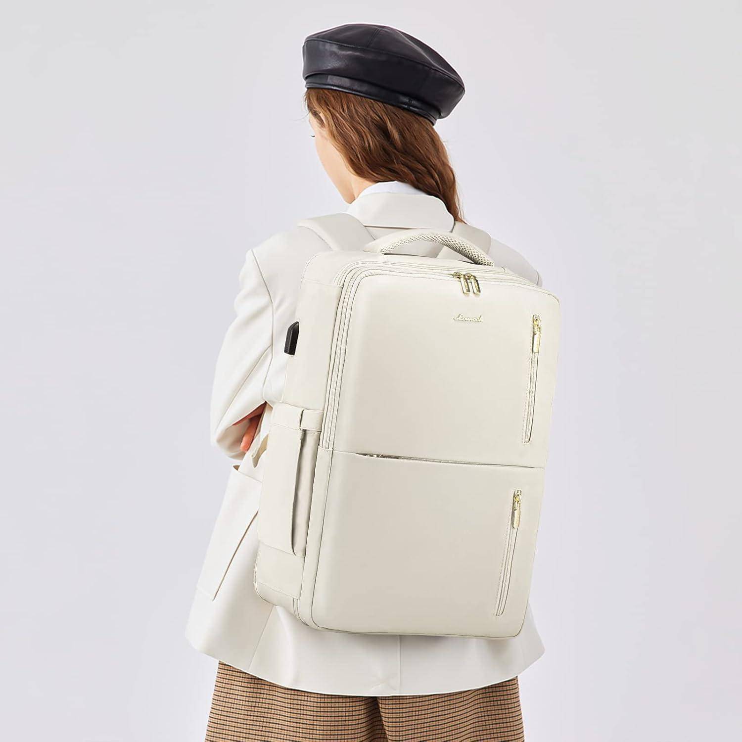 Eine Frau mit weißem Blazer und schwarzem Beret wird von hinten gesehen, wie sie einen großen, schlanken weißen Rucksack trägt.