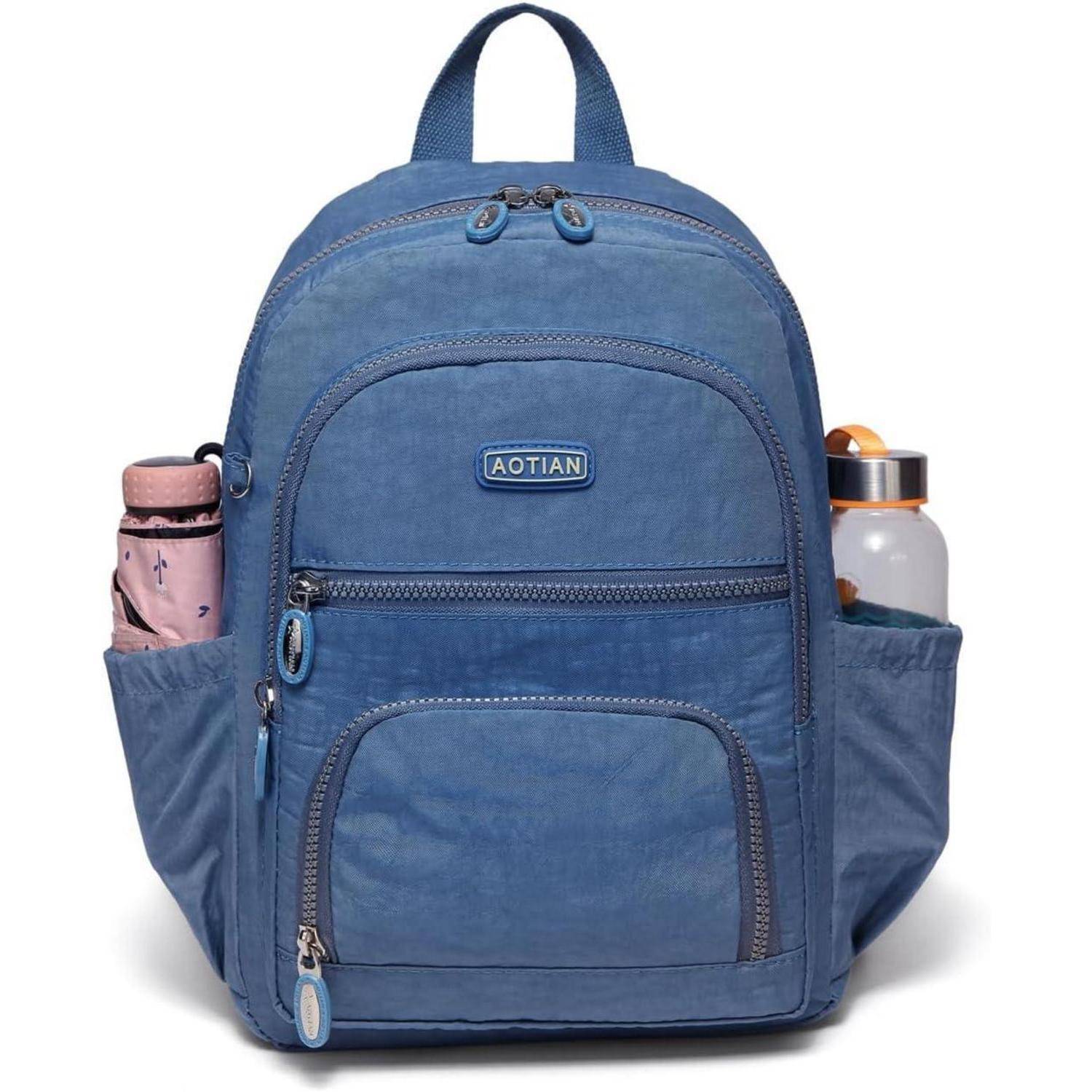 Ein blauer Rucksack mit mehreren Fächern, Seitentaschen, die eine rosa Flasche auf der linken und eine weiße Flasche auf der rechten Seite halten, mit der Aufschrift 