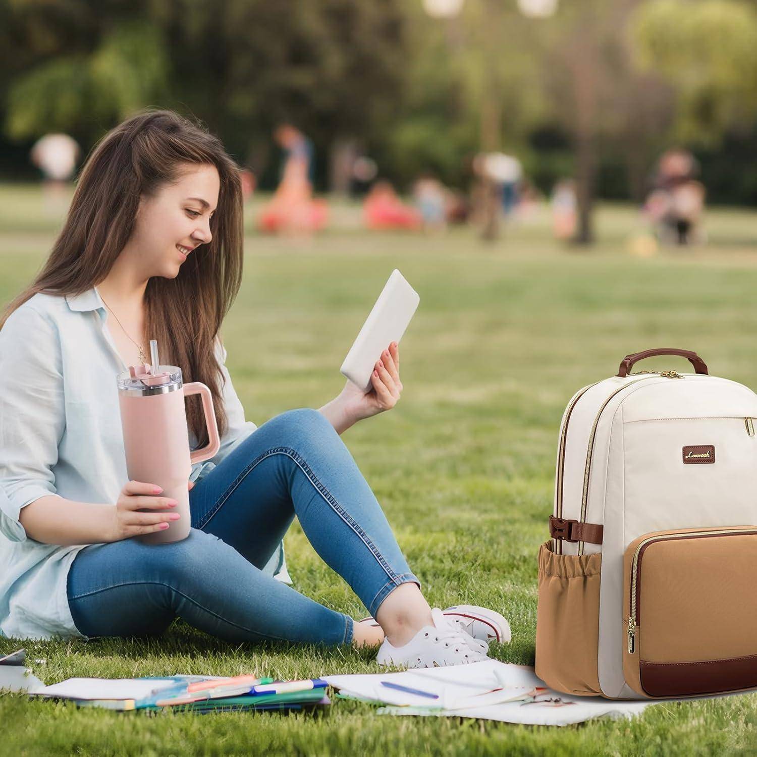 Eine junge Frau sitzt auf dem Gras in einem Park, hält ein Buch und einen Becher. In der Nähe liegen ein Rucksack und verstreute Papiere. Es ist ein sonniger Tag.