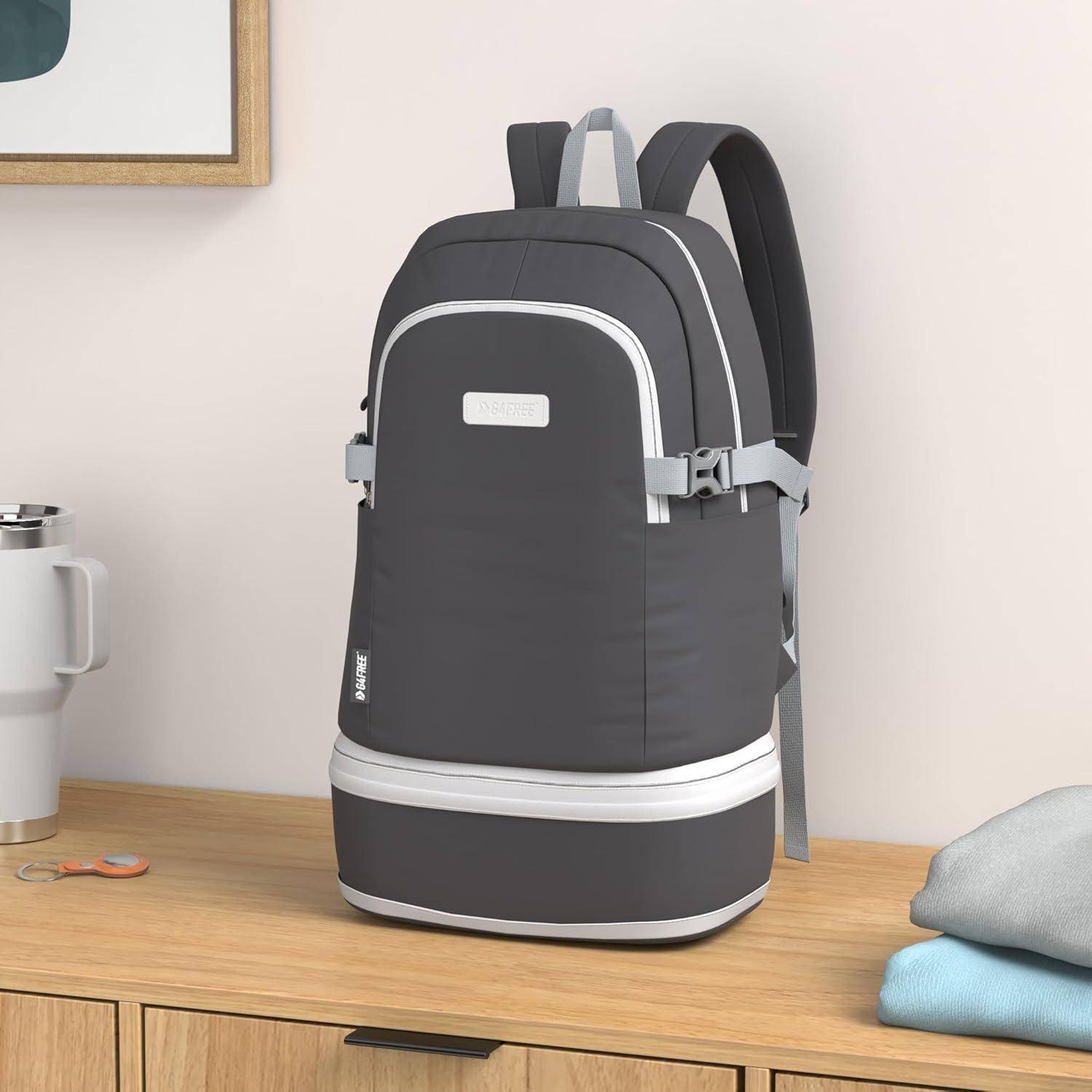 Ein grauer Rucksack mit weißen Akzenten liegt auf einem Holztisch. Eine weiße Tasse, ein Schlüssel und ein gerahmtes Bild befinden sich in der Nähe.