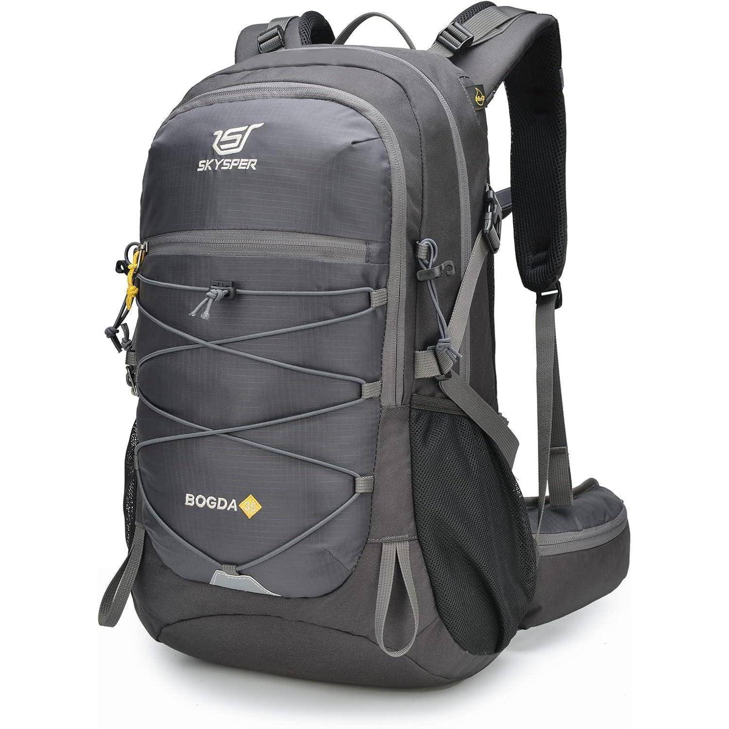 Grauer Rucksack mit mehreren Fächern, verstellbaren Trageriemen und vorderen elastischen Kordeln zur Aufbewahrung. Markenlogos von 'SKYSPER' und 'BOGDA' sichtbar.