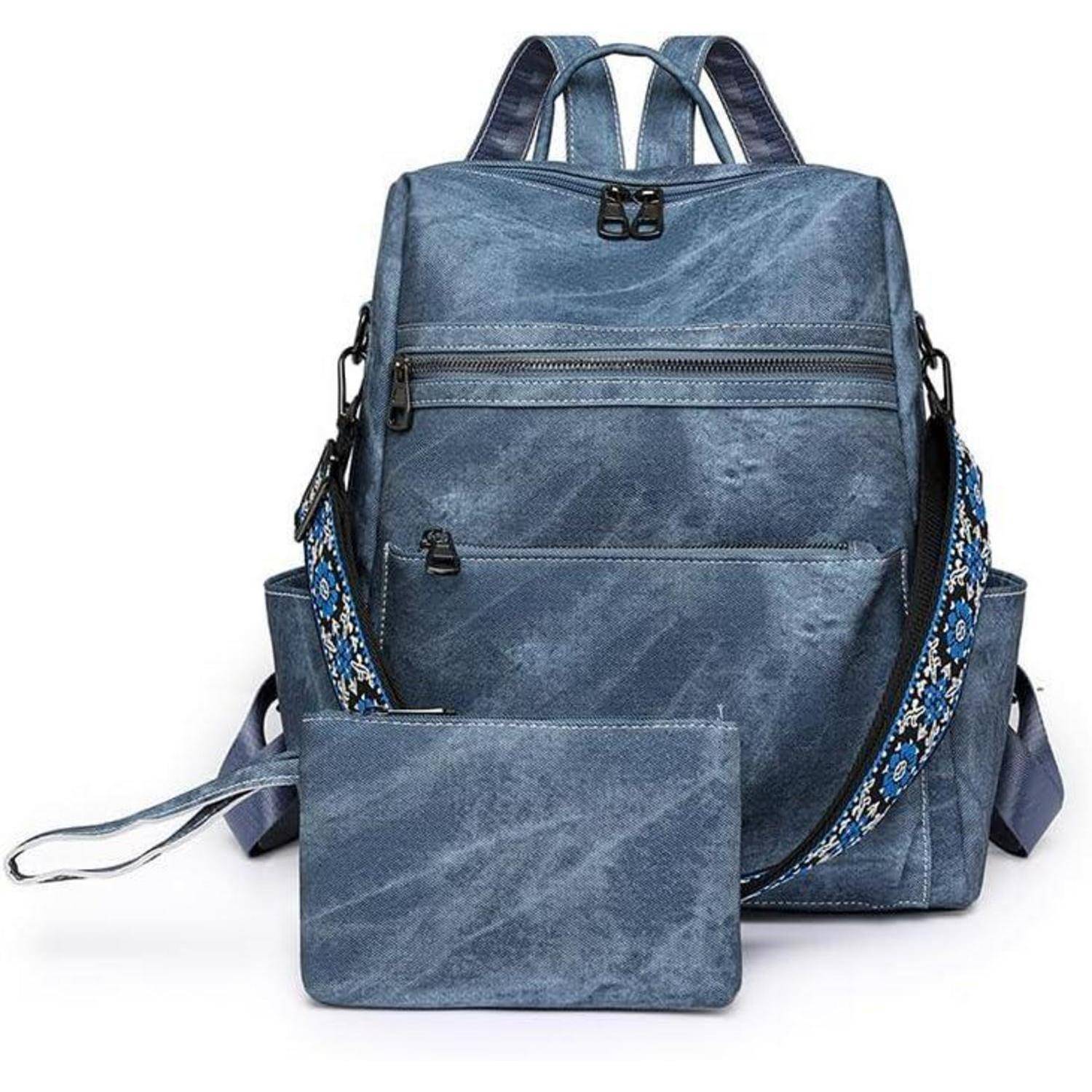 Ein blauer Rucksack mit einer passenden Clutch und einem blumengemusterten Riemen wird vor einem weißen Hintergrund präsentiert.