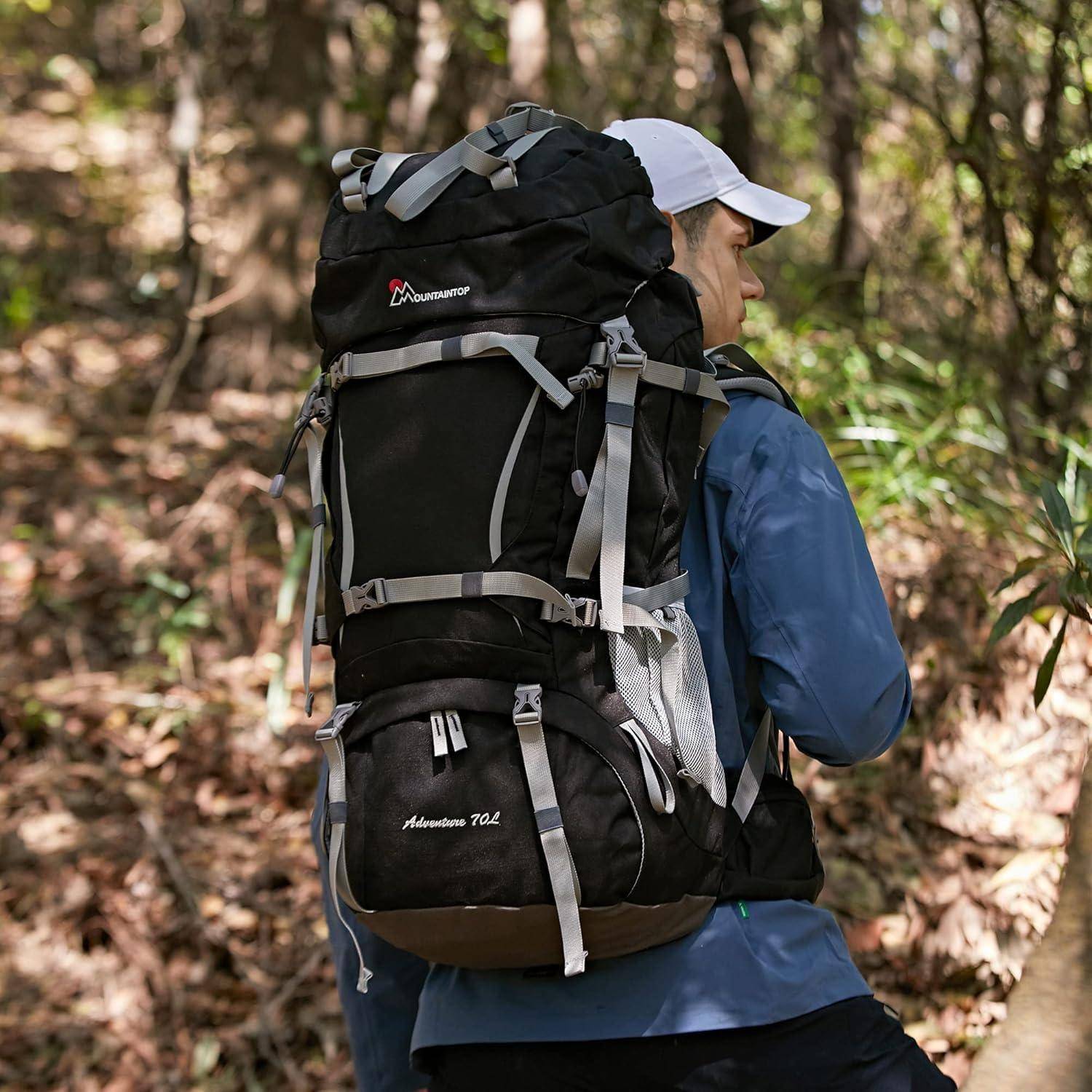 Eine Person, die durch ein bewaldetes Gebiet wandert und einen großen schwarz-grauen Rucksack trägt, mit Fokus auf Outdoor-Erkundung.