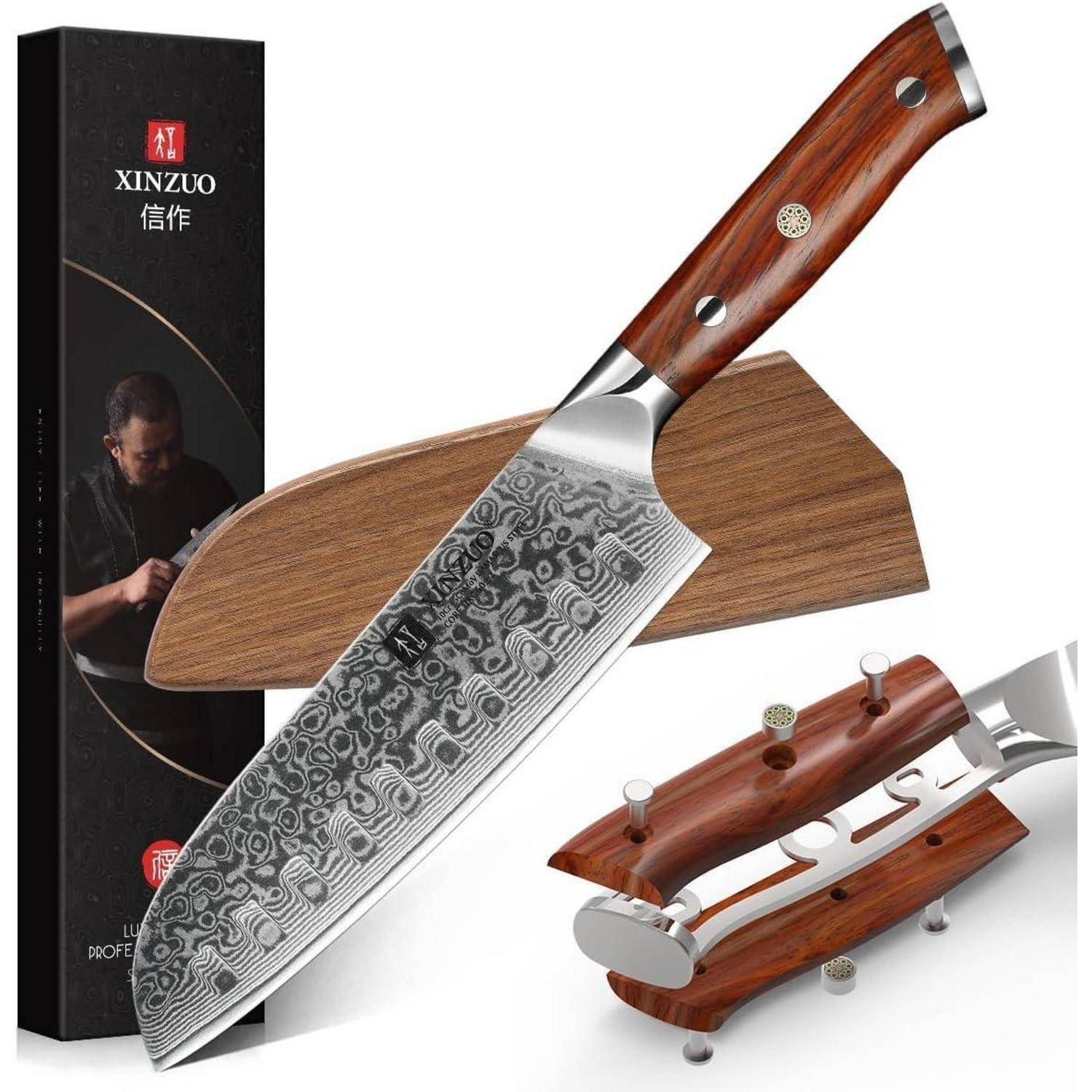 Ein Chefmesser mit gemusterter Klinge und Holzgriff, präsentiert mit einer Schutzscheide. Eine Schachtel im Hintergrund zeigt das Markenlogo.