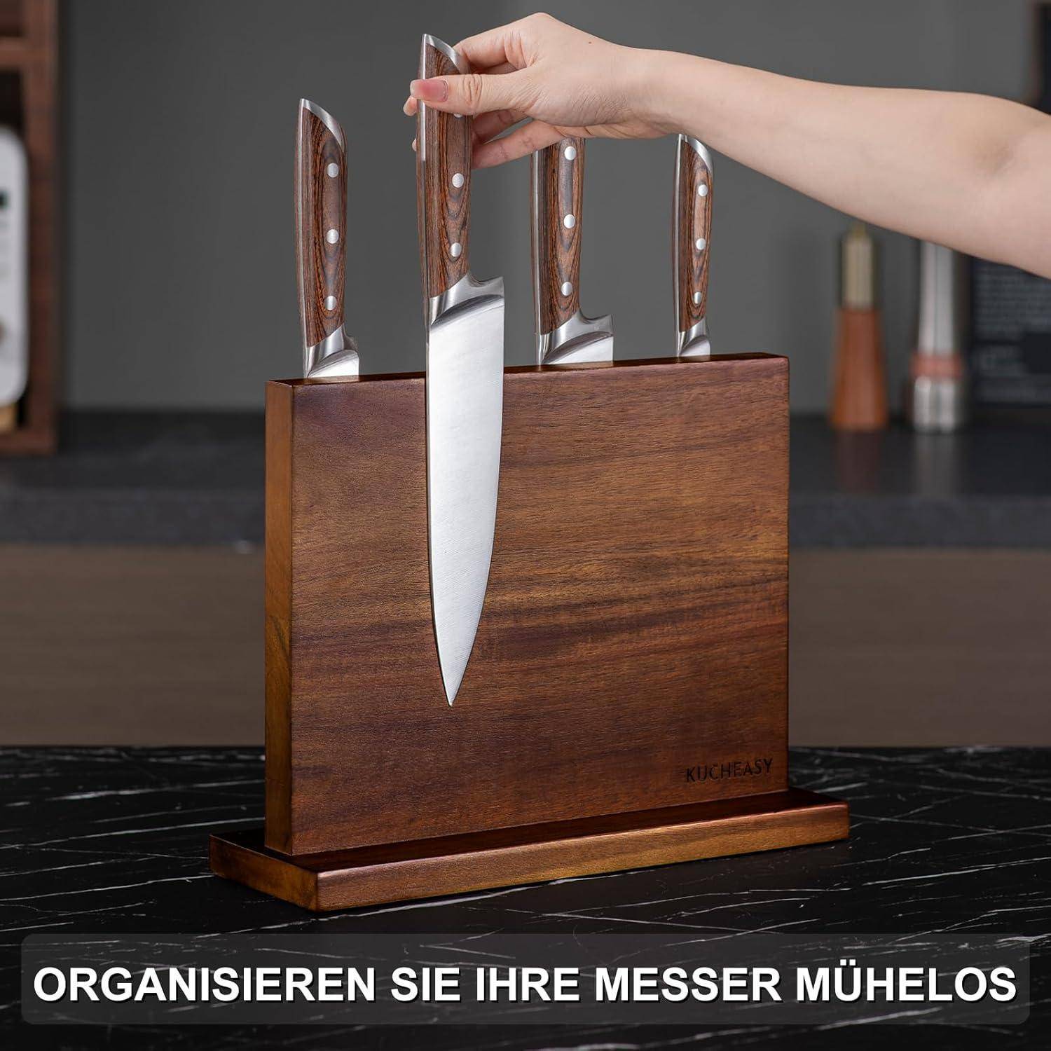 Ein Händepaar legt ein Küchenmesser in einen Holz-Messerblock, der mehrere Messer enthält. Der Text lautet: 'ORGANISIEREN SIE IHRE MESSER MÜHELOS'.