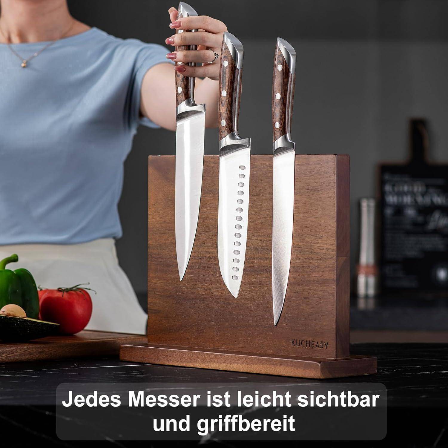 Eine Person steckt ein Messer in einen Holzmesserblock, in dem drei Messer sichtbar sind. Gemüse liegt auf der Arbeitsplatte. Text lautet: 'Jedes Messer ist leicht sichtbar und griffbereit.