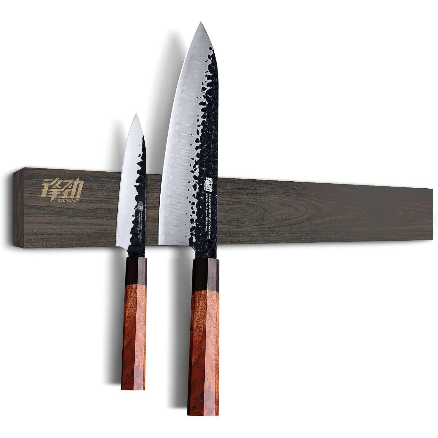 Zwei japanische Messer mit Holzgriffen sind magnetisch an einem dunklen Holzmesserhalter befestigt, der an einer Wand montiert ist.
