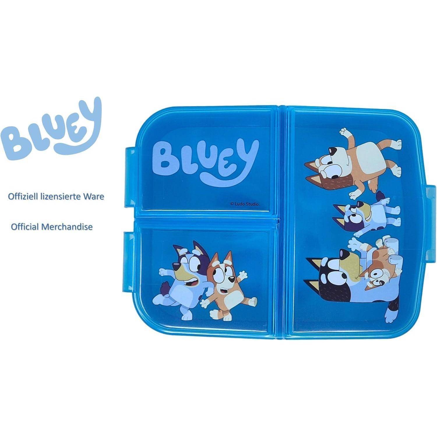 Eine blaue Brotdose mit 'Bluey' Schriftzug und Zeichentrickfiguren auf dem Deckel. Sie zeigt Szenen von verspielten Zeichentrickhunden auf einem hellblauen Hintergrund.