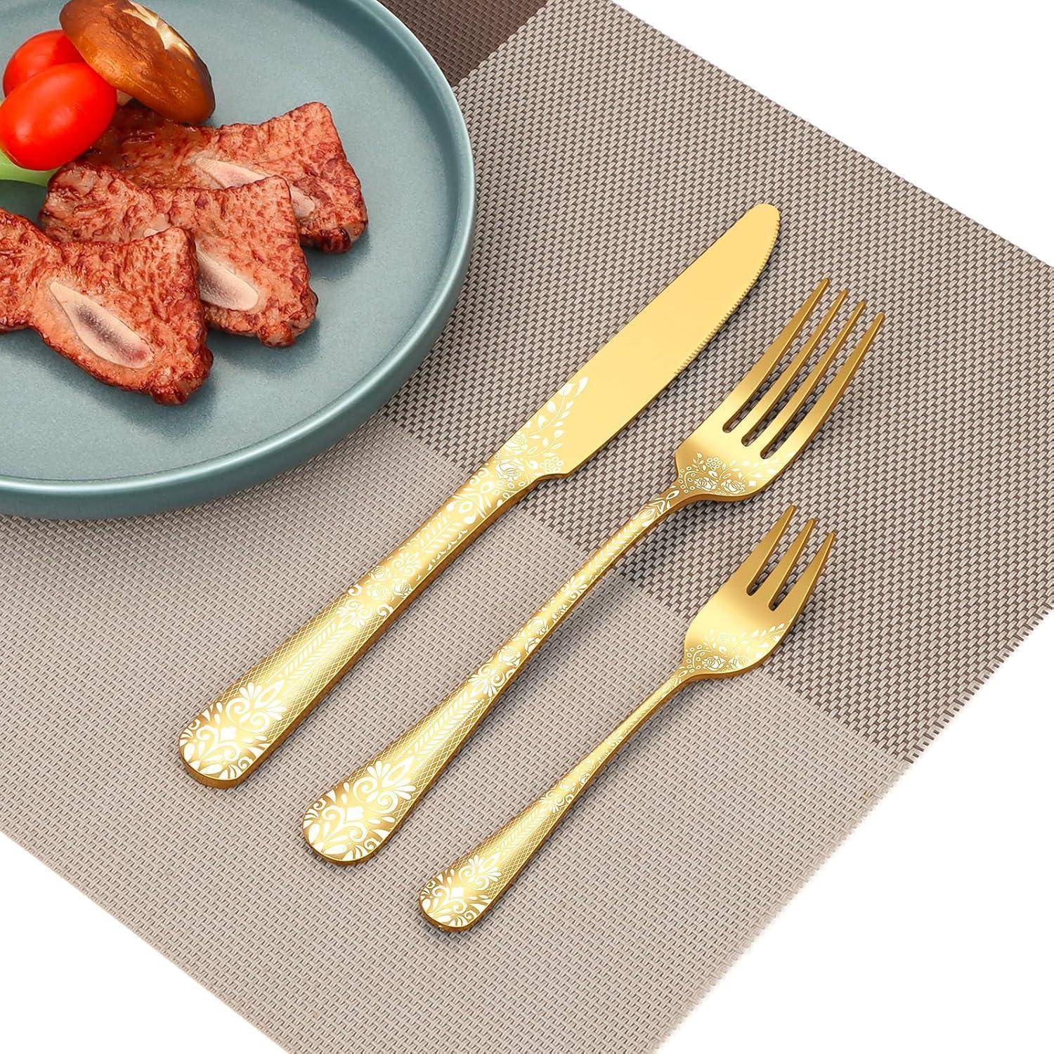 Ein Teller mit Spielzeug-Steakscheiben und einem Pilz neben einer goldenen Gabel, einem Messer und einem Löffel auf einem karierten Platzdeckchen.