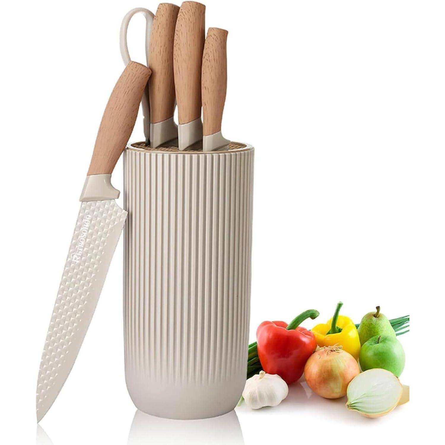 Ein Messer-Set mit Holzgriffen in einem Messerblock, zusammen mit buntem Gemüse wie einer Paprika, einer Zwiebel und einer Tomate.