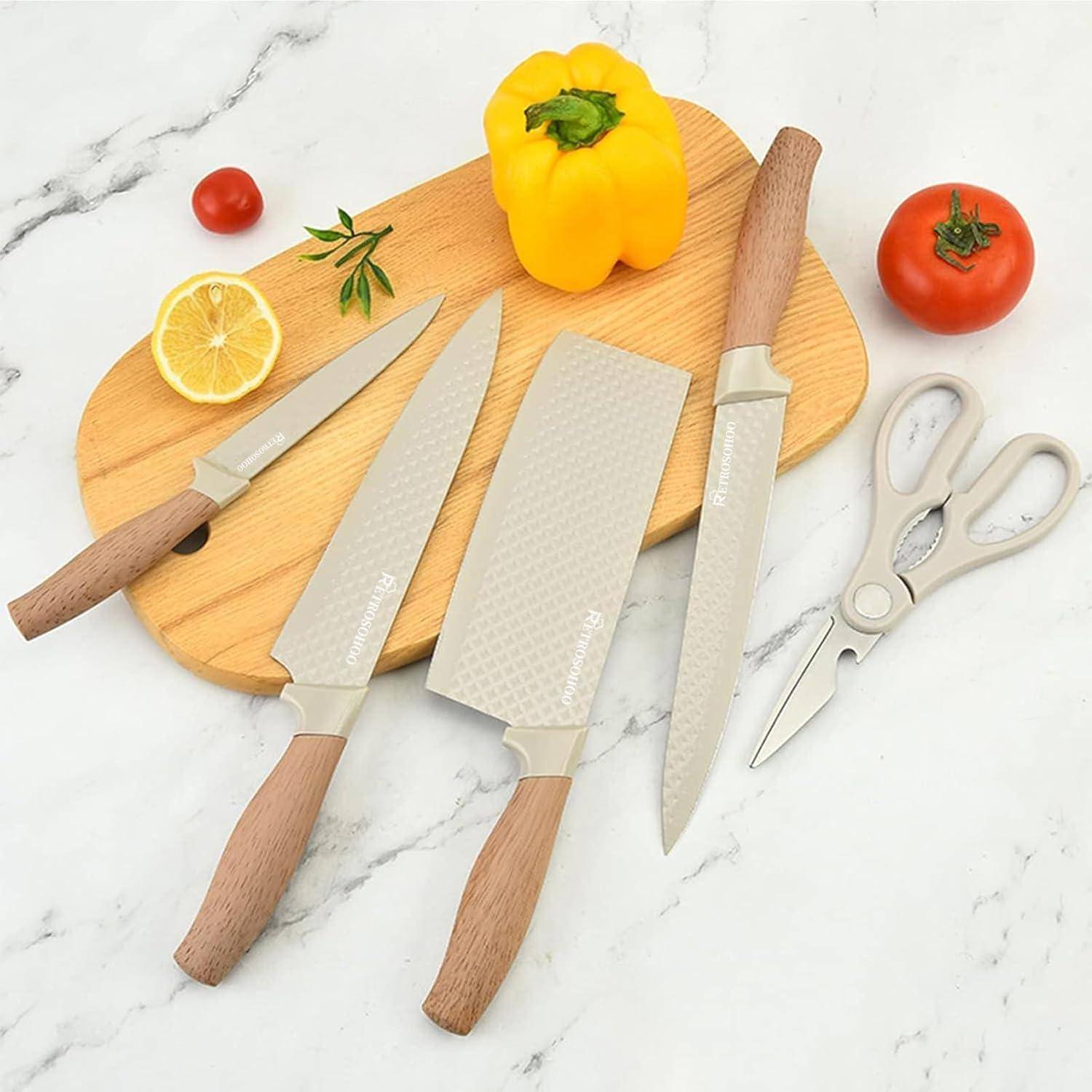 Ein Set Küchenmesser und Scheren mit Holzgriffen wird auf einem Schneidebrett präsentiert, umgeben von Gemüse und einer Zitronenscheibe.