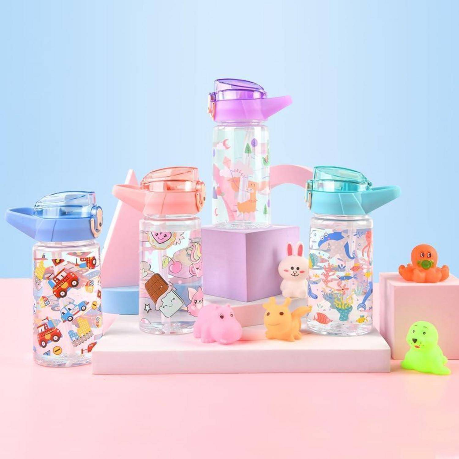 Vier bunte Wasserflaschen mit Cartoon-Druckdesigns auf einem Pastellhintergrund, umgeben von kleinen Spieltierchen.