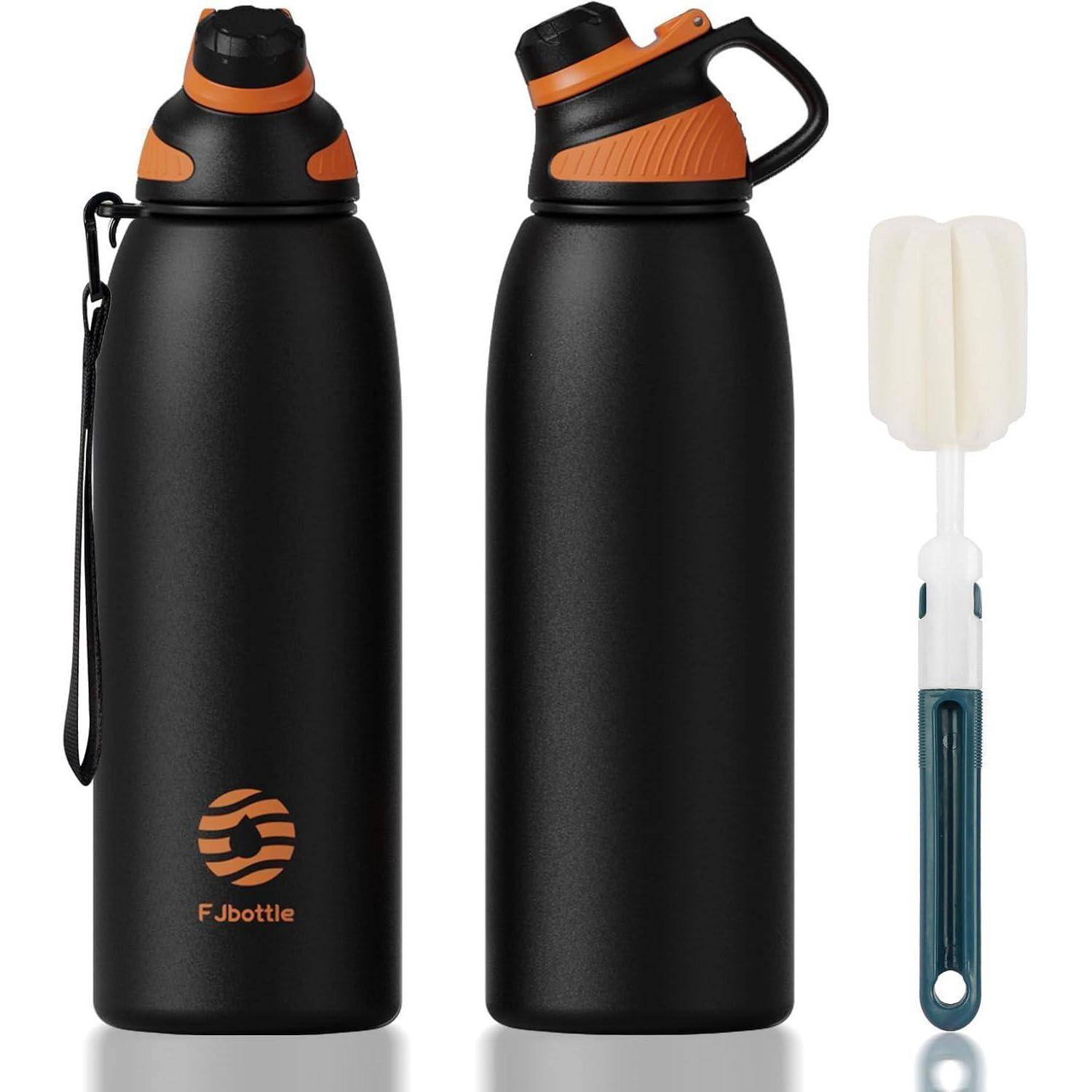 Zwei schwarze Fjbottle Isolierwasserflaschen mit orangefarbenen Verschlüssen, eine davon mit Griffanbringung, und eine weiße Reinigungsbürste daneben.