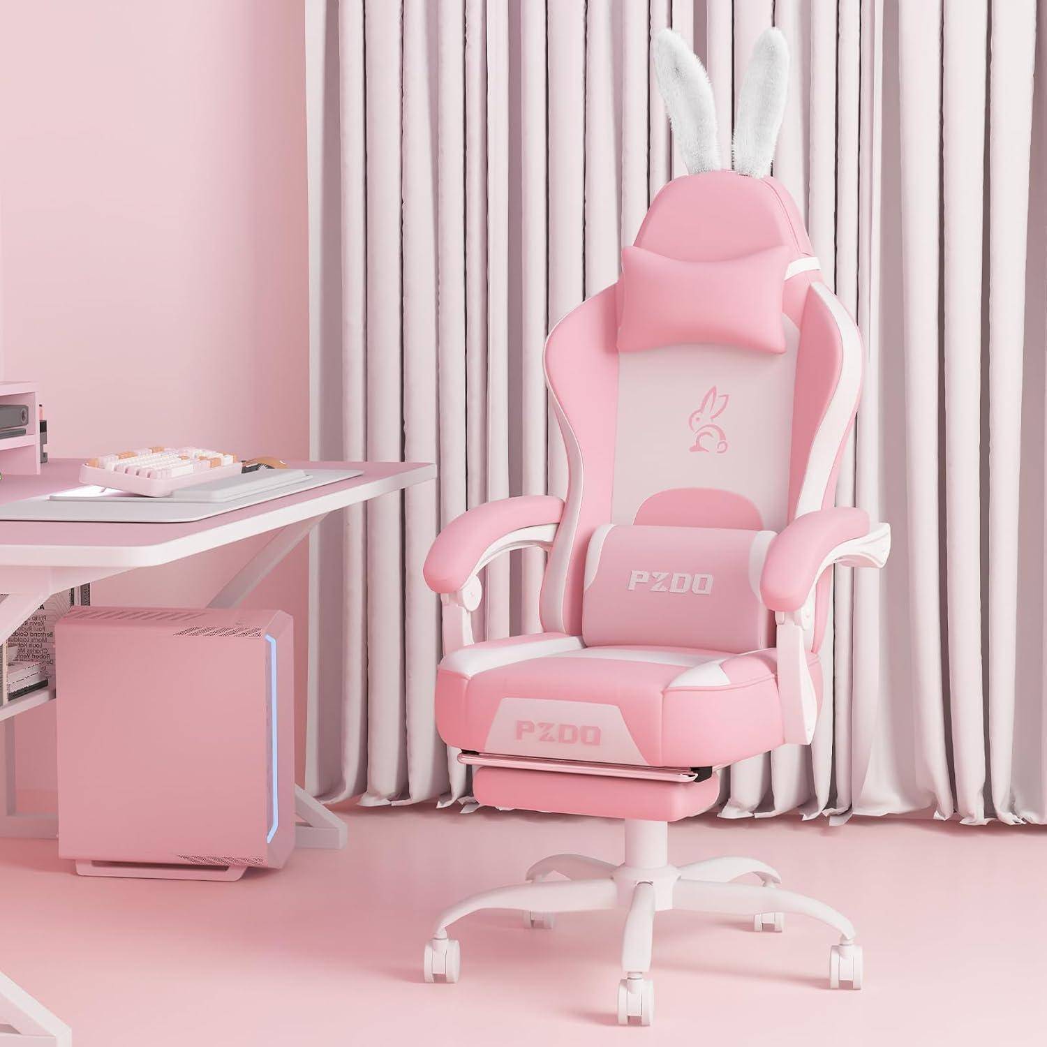 Ein pinker Gaming-Stuhl mit weißen Akzenten und Hasenohren-Anhängern steht neben einem modernen Schreibtisch, alles in einem pastellrosa Raum.