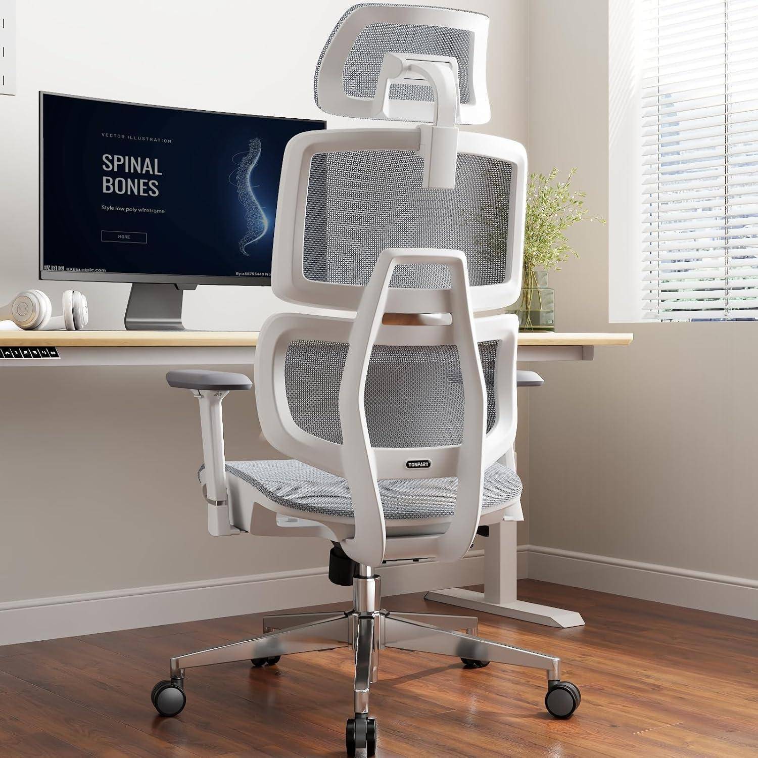 Ein moderner ergonomischer Bürostuhl mit Netzrücken und Kopfstütze vor einem minimalistischen Schreibtisch mit einem Monitor, der einen 