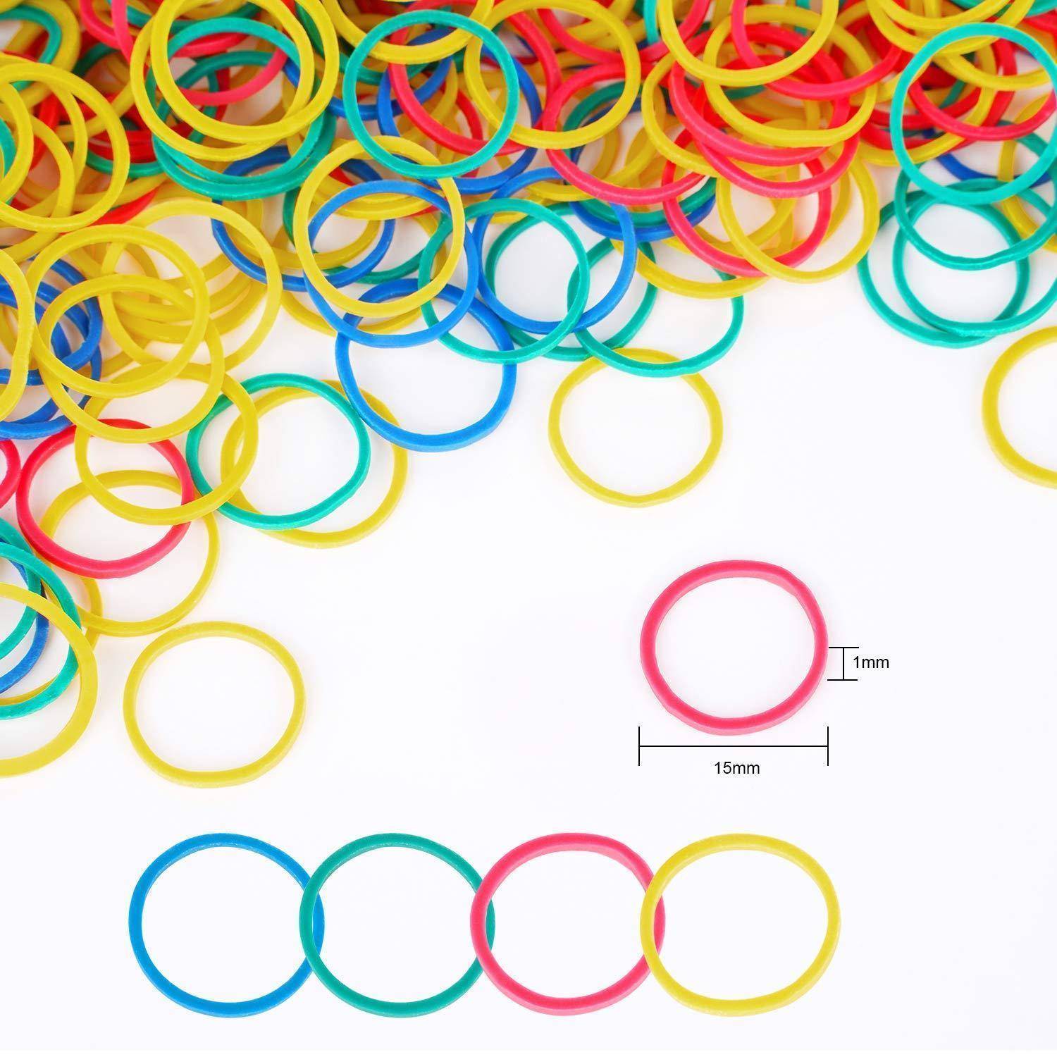 Bunte Gummibänder sind verstreut, hauptsächlich in Gelb, Rot und Blau. Eine Nahaufnahme hebt ein Band mit folgenden Abmessungen hervor: 15 mm Durchmesser, 1 mm Dicke.