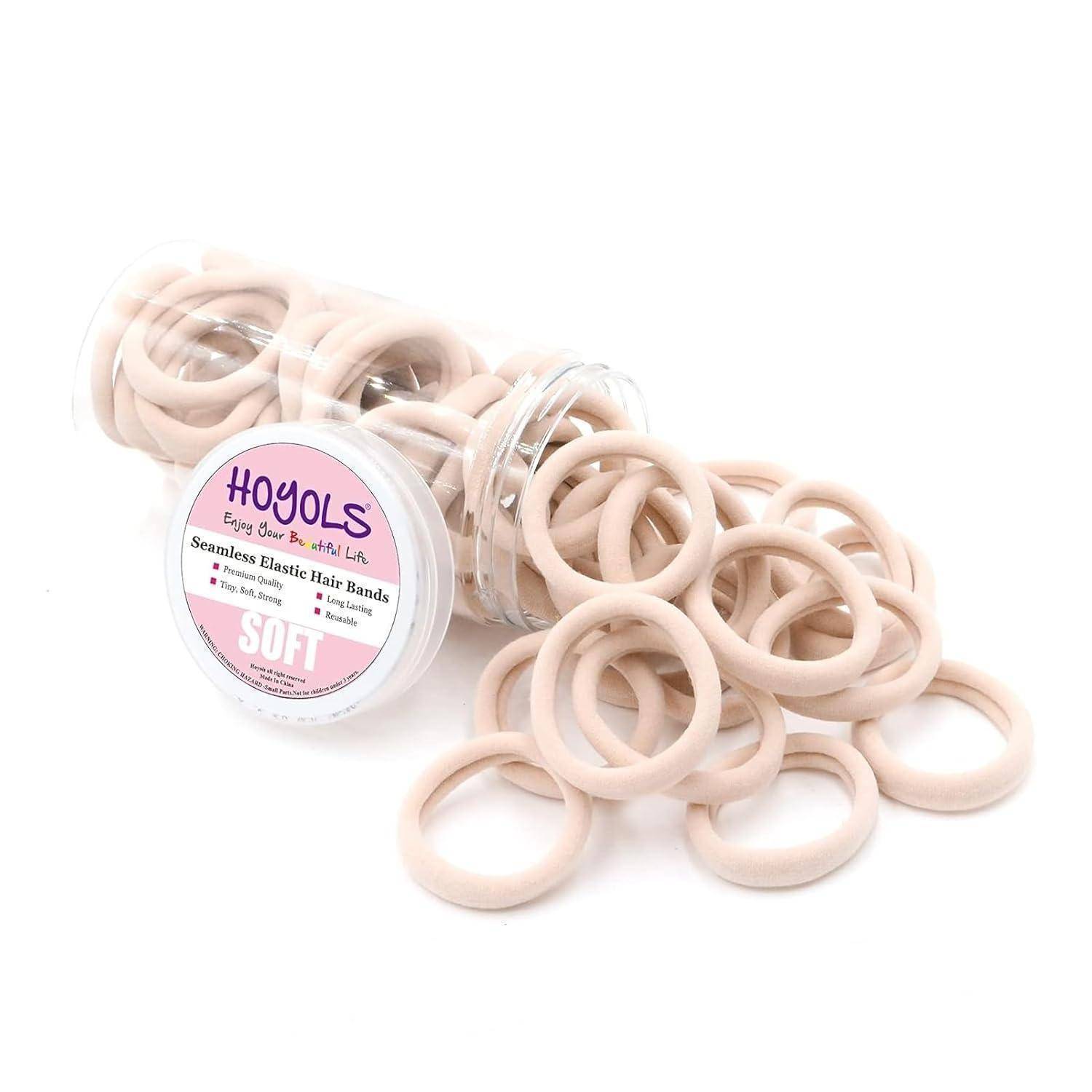 Ein durchsichtiger Behälter verschüttet hellbeige, nahtlose elastische Haarbänder mit der Aufschrift „Hoyols Soft