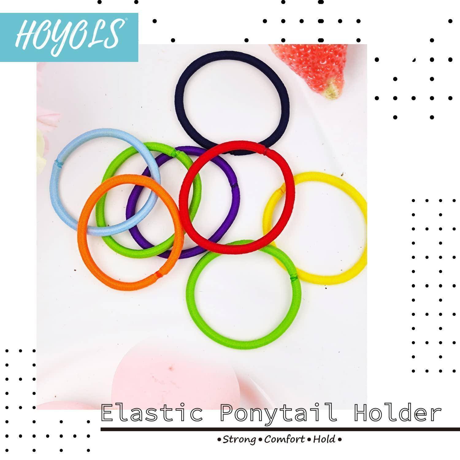 Bunte elastische Haargummis, die in einem Kreis angeordnet sind und blaue, rosa, orange, schwarze, rote, lila und grüne Bänder auf weißem Hintergrund zeigen.