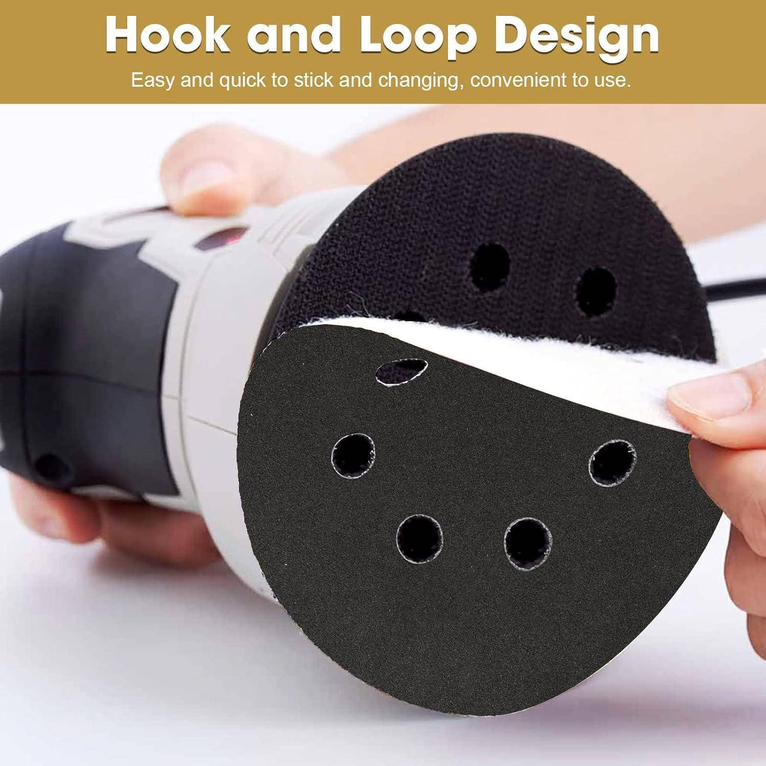 Eine Hand hält ein schwarzes Schleifpad, das sein ‚Hook and Loop Design' gegen einen Schleifer zeigt und dabei die einfache Befestigung und Entfernung betont.