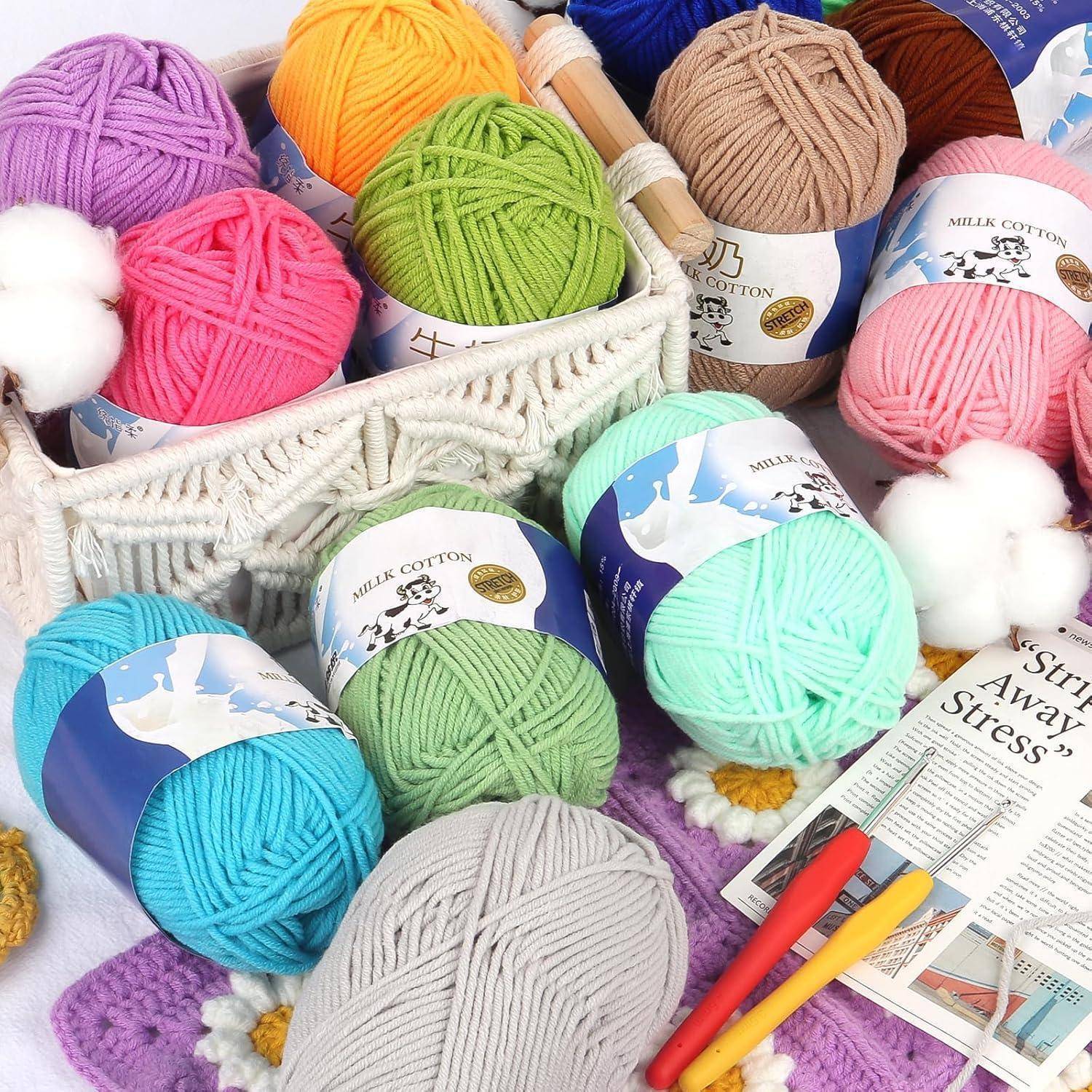 Bunte Wollknäuel in einem Korb mit Stricknadeln. Etiketten zeigen verschiedene Farben wie Rosa, Grün, Blau und Orange.