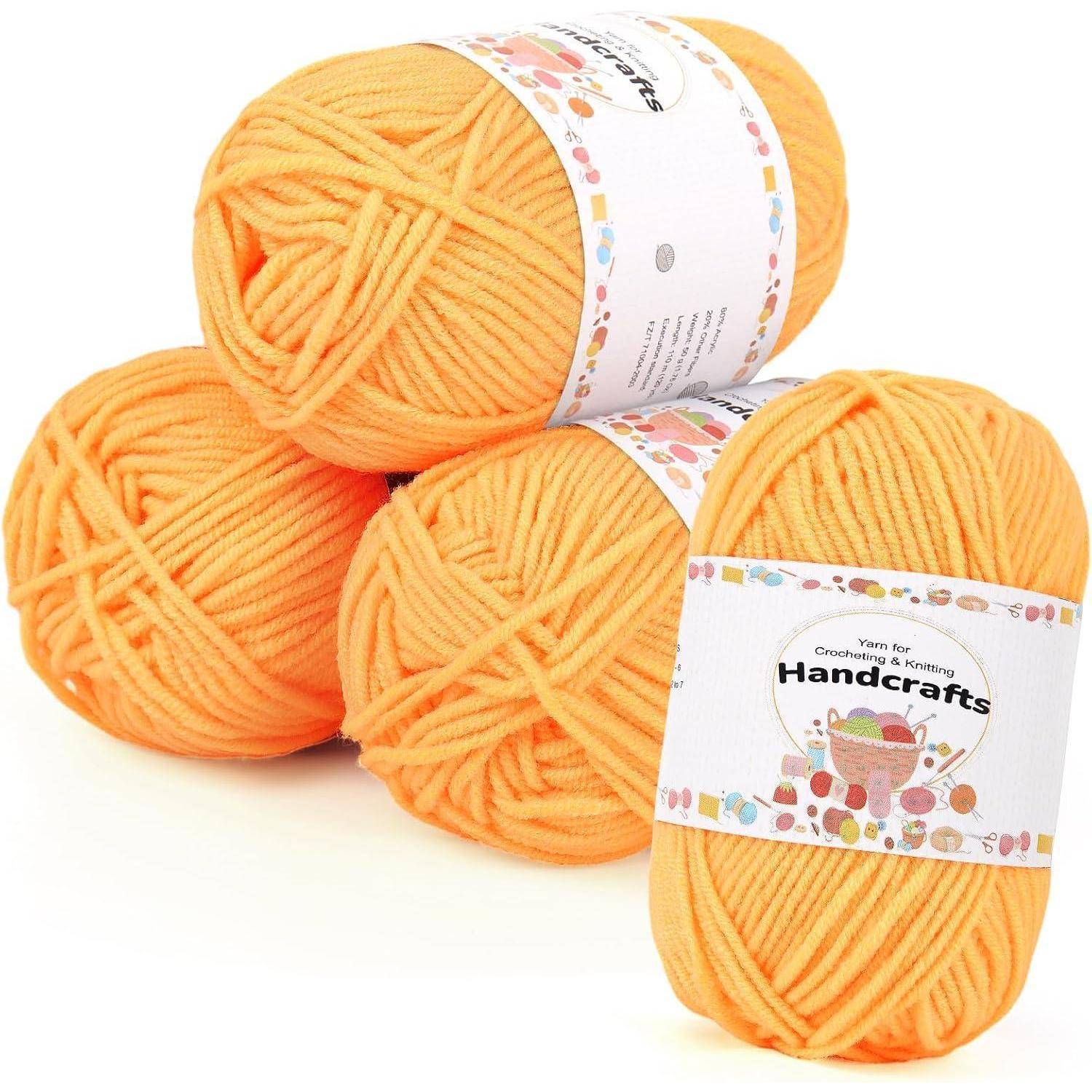 Drei Knäuel orangefarbenes Garn für Handarbeiten, gekennzeichnet zum Häkeln und Stricken.