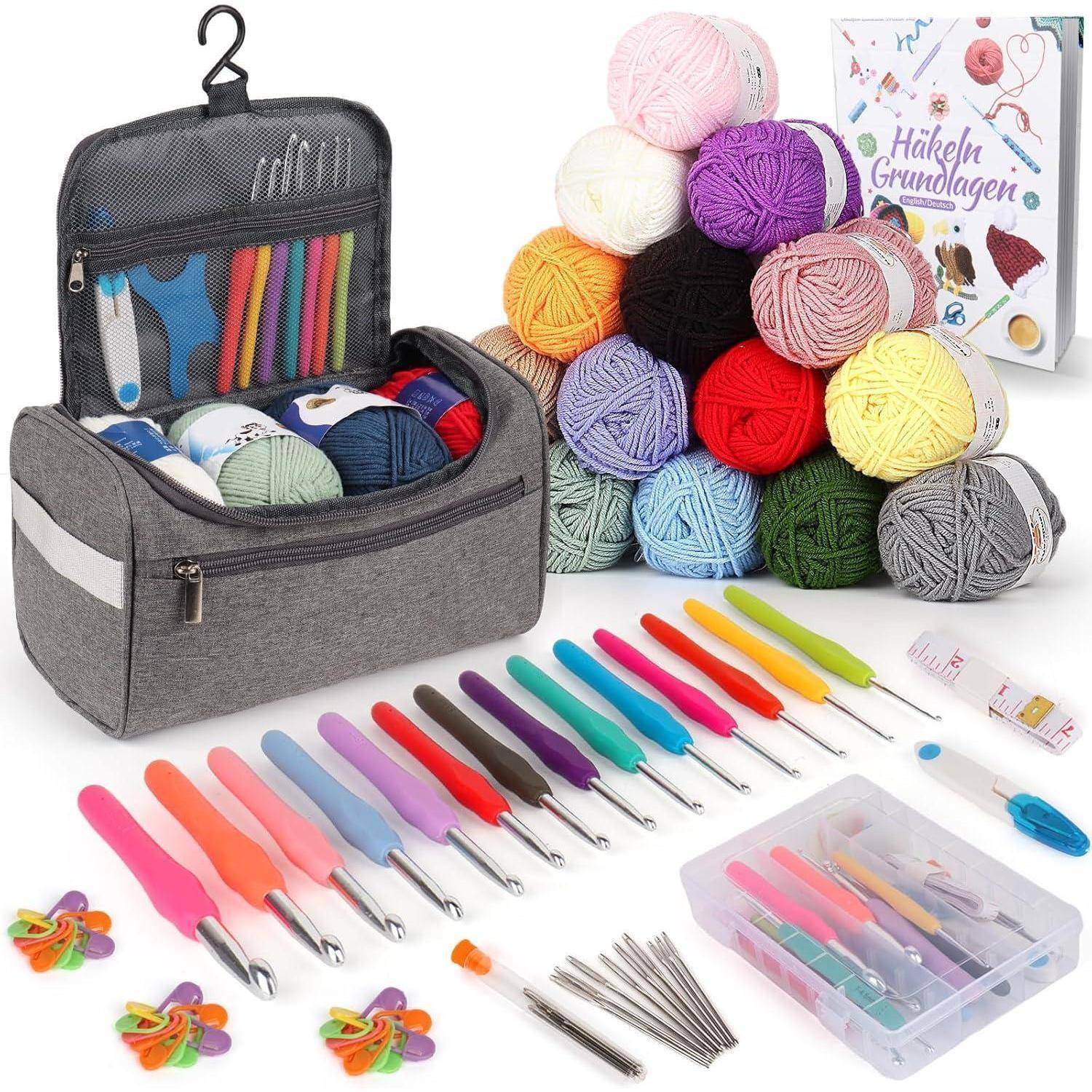 Set zum Häkeln mit bunten Häkelnadeln und Garn in verschiedenen Farbtönen. Enthält Werkzeuge in einer grauen Tasche und ein Buch mit dem Titel „Häkel Grundlagen