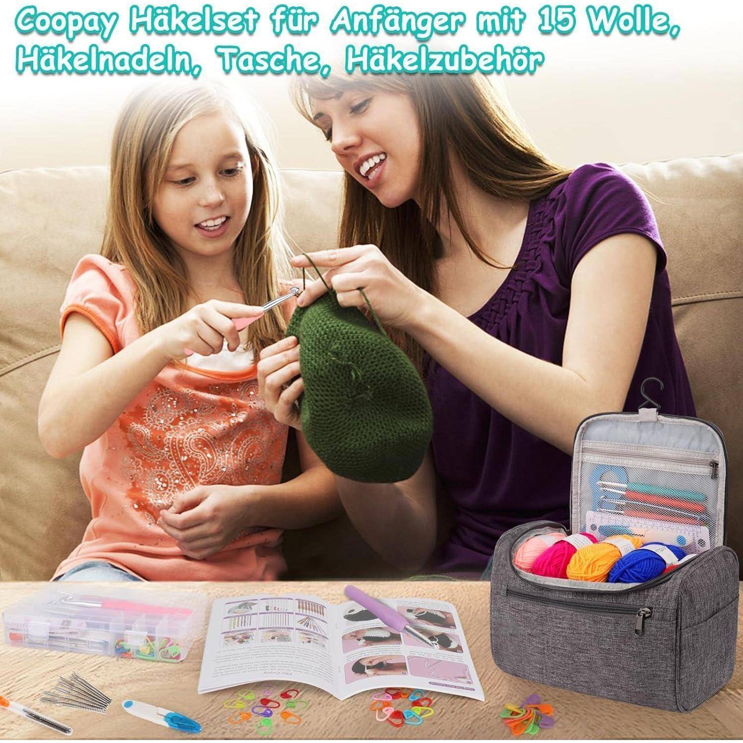 Eine Mutter und ihre Tochter häkeln gemeinsam und verwenden dabei grüne Wolle. Eine Garn- und Werkzeugausrüstung mit Häkelnadeln und bunten Fäden liegt auf dem Tisch in der Nähe.