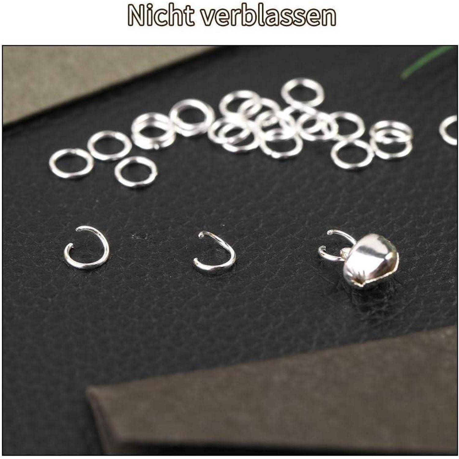 Eine Nahaufnahme von kleinen silbernen Biegeringen auf einer schwarzen Oberfläche mit dem Text 'Nicht verblassen' darüber, was andeutet, dass die Ringe nicht anlaufen.