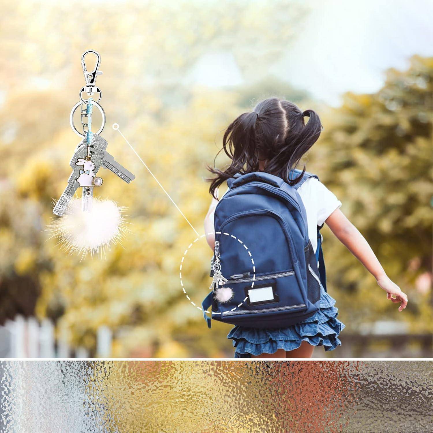 Ein Kind mit einem Rucksack, der ein Anhänger-Accessoire trägt, durch eine gepunktete Linie verbunden mit einer Nahaufnahme von Schlüsseln mit einem Fellanhänger.