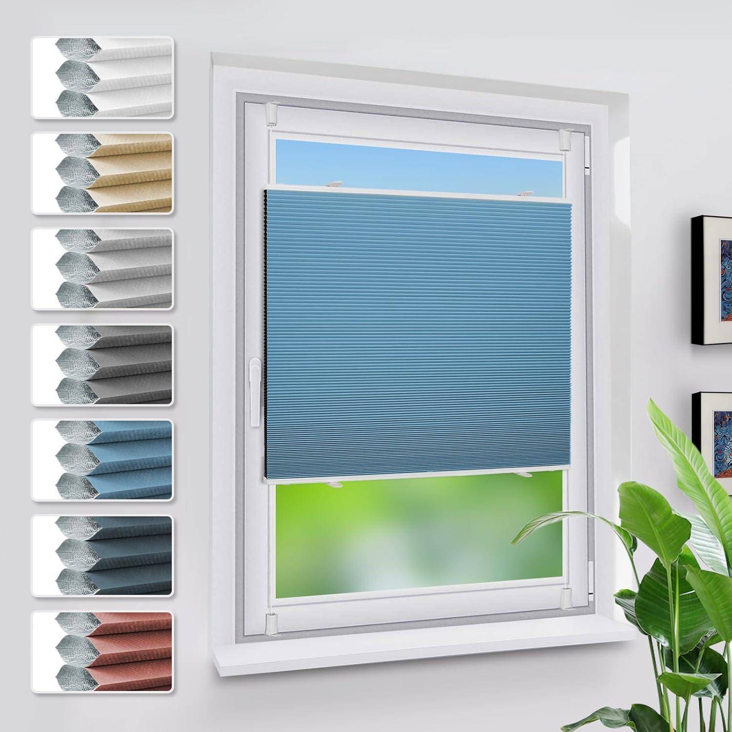 Ein Fenster mit einer teilweise heruntergelassenen blauen Plissee-Jalousie. Auf der linken Seite des Bildes sind Stoffmuster in verschiedenen Farben ausgestellt.