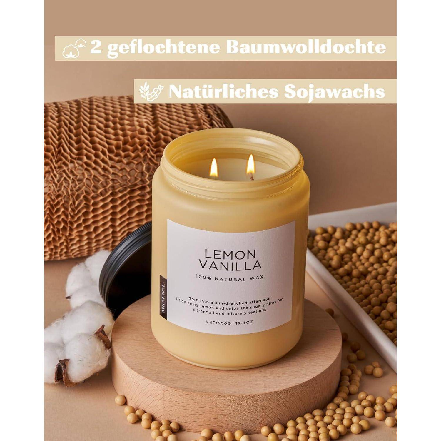 Ein Glas einer 'Zitrone Vanille' duftenden Kerze aus natürlichem Sojawachs mit zwei Baumwolldochten, umgeben von Sojabohnen und Baumwolle auf einer Holzbasis.