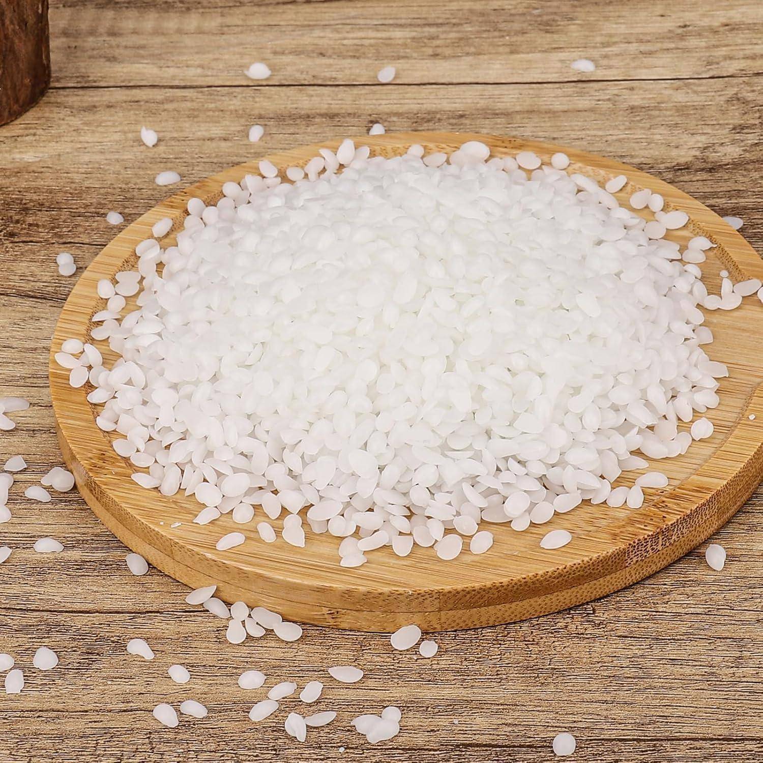 Eine runde Holzplatte, gefüllt mit ungekochten weißen Reiskörnern, die auf einer Holzoberfläche positioniert ist, mit einigen verstreuten Reiskörnern drumherum.